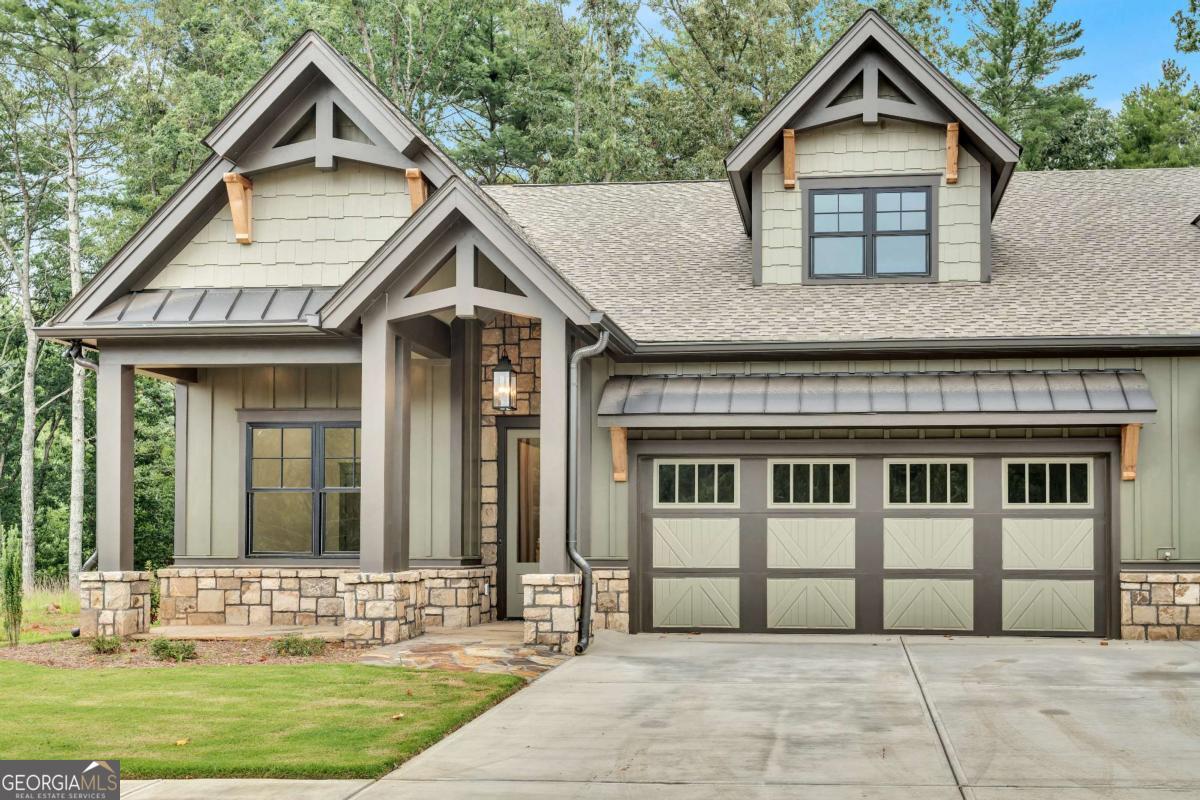 **$2,500 Custom Interior Paint Allowance & $2,200 Refrigerator Allowance** Imagine yourself in a charming Dogwood Cottage nestled in Active Adult Community of The Village on Blackwell Creek, a community with multiple stunning homes completed and under construction. With the convenience of future on-site amenities, as well as the option to buy-in to nearby Big Canoe community amenities, this community has all of the comfort of a small community, with all of the benefits of a larger HOA! Each townhome cottage offers the ease of main-floor living, with 1,655 square feet featuring a serene master suite, a cozy secondary bedroom with its own bathroom, and soaring 11-foot ceilings that create an open, airy ambiance. Wide 8-foot doors, vaulted ceilings, and gorgeous manufactured hardwoods throughout the main level, enhances the sense of space and flow. The gourmet kitchen is a cook's dream, complete with gleaming stone countertops, abundant cabinetry and extra pantry space, a gas range, and a spacious island with an integrated sink-perfect for preparing meals while entertaining guests. Step outside onto the generous rear covered screened porch that overlooks peaceful green space, ideal for relaxing in the fresh air. Upstairs includes an additional bedroom and full bath, ideal for guests, caregivers, or even a home office, with low maintenance luxury LVP flooring throughout. With a two-car garage, convenient main-floor laundry room, wired for a generator, and thoughtful layout ensure comfort and practicality throughout. The association fee covers insurance, all exterior building maintenance, landscaping, trash pickup, internet, and TV service-and nearby walking trails and pavilions giving you a carefree lifestyle in a nature-filled sanctuary that feels like a luxurious retreat every single day. Only attached at the garage and with sound-proofing and insulating spray foam throughout- this property lives like a fully detached home! Additional fully completed properties for sale in the community. These properties won't be available for long... schedule your showing today!!