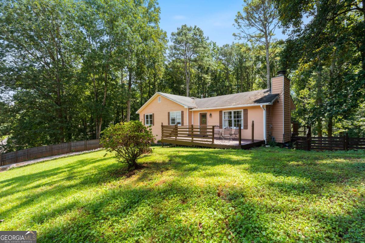 A Charming Canvas with Room to Grow!! Tucked away on just over an acre in the beloved Pine Acres community, this 3-bedroom, 2-bath raised ranch is that rare mix of peace, privacy, and prime location you've been waiting for. Inside, you'll love the welcoming living room with its raised hearth, cozy fireplace, a bright kitchen and breakfast nook, and a full basement already stubbed for a bath-ready to transform into a guest suite, media room, or home gym. With a newer HVAC and water heater, comfort and efficiency are already built in. Step onto your front or back porch and listen-nothing but birdsong. The home is surrounded by mature landscaping and fruit trees, with a privacy fence that wraps the property (just add gates to complete your own private retreat). And the location? Ideal. You're minutes from the I-575 express lanes and Hwy 5, making commutes effortless. Downtown Woodstock's shops, dining, and concerts are right nearby, and you're only 3 miles from the upcoming Holly Springs Downtown District and Amphitheater-soon to be the area's hottest destination for music, food, and community. In the highly sought-after Sequoyah School District, this home checks all the boxes: master on main, over an acre of land, room to expand, and endless potential. Ask about our buyers credit when using our preferred lender! ? Homes like this don't last-schedule your showing today and come see why this Pine Acres gem is the perfect backdrop for your next chapter! ?