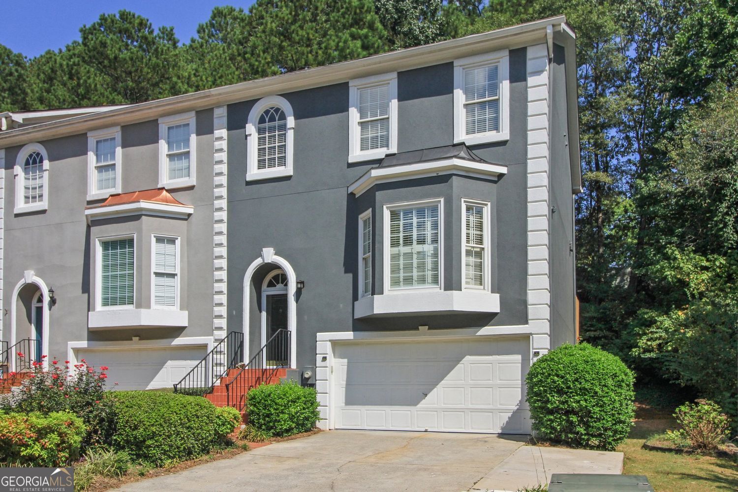 TOTAL RENOVATION of this charming and spacious Charleston Bay townhome! Enjoy the wide staircases, beautiful hardwoods, new lighting, carpet, LVP on lower level, and opened-up flow maximizing modernization and functionality. A chef's dream of a kitchen with stone counters, stainless steel Kitchen Aid appliances, custom soft-close cabinetry and plenty of storage. Notice the added lovely kitchen island/breakfast bar and bay window area bathing the room with tons of natural light. Entertain away in the generous dining area leading seamlessly into the family room with fireplace flanked on either side by appealing built-ins. Take the gathering outside to the expansive deck and enjoy a bit of Mother Nature! A true move-in-ready delight as every room has been touched! Newly painted throughout, ALL bathrooms tastefully renovated from top to bottom. The lower level off the 2-car garage features a sizeable bedroom with en-suite bath, the laundry, and a private and serene patio area for relaxing. Two additional bedrooms are above the main living area level. Enter the primary suite through stately French doors and be wowed by its size, stylish accent wall, new carpet and tremendous spa-like bath with glass shower, bathtub, double vanities and custom cabinetry! A secondary bedroom with newly renovated en-suite bath completes the picture on this level. This charming community is centrally located in Duluth with great proximity to Peachtree Industrial Blvd along with I-85 making commuting a breeze. Convenience to nearby Northside Hospital Duluth is an added benefit, and let's not forget the charming downtown area with all it has to offer with shops, restaurants, parks, and events. This meticulously maintained and renovated townhome is the one to call HOME!!