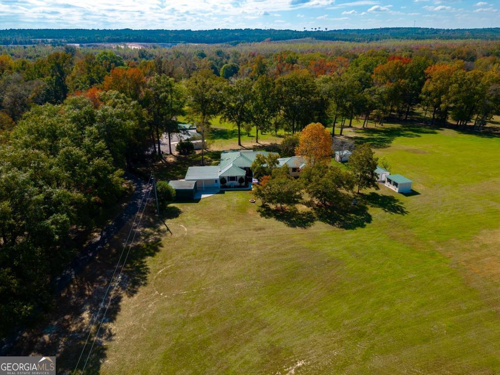 Echeconnee Creek Hideout is an incredible homestead opportunity in Bibb County, GA. The location of this property is incredible. The water features and natural beauty of this place are going to be impossible to match or ever replicate this close to Macon & Warner Robbins. The main house is excellent. The views facing the back of the property are incredible. It sits up upon a knoll as the land gently rolls back towards Echeconnee Creek & the stocked pond. The inside is very appealing. New floors throughout, nice appliances & fixtures, billiards room, and much more! The main house excellent. The views facing the back of the property are incredible. It sits up upon a knoll as the land gently rolls back towards Echeconnee Creek & the stocked pond. The inside is very appealing. There are 3 bedrooms & 3 bathrooms, which are all good size! New floors throughout, nice appliances & fixtures, billiards room, exercise room, and much more! There is a backup generator also on site. Several outbuildings & equipment barns are located here. There is to many amenities to list. Beautiful Echeconnee Creek flows along the back property line for just under a half mile. The fishing is incredible. The red breast fishing in this creek is some of the best around. There are several sand bars along the creek that will make excellent relaxation places for family & friends. Large groups of wood ducks have been seen while visiting the property in the last several weeks. The one acre stocked pond adds an additional water feature to this already water rich property. There are several long-range views overlooking the pond from the home. Creeks or ponds are a must for many buyers in this market, and this property happens to offer the best of both worlds. The hunting here will be fantastic. The current owners do not hunt, and leave the wildlife completely unbothered. However, there are some big bucks traveling Echeconnee Creek, and several open areas are located on sight, and would make great food plot areas. Mast producing hardwoods can be found all over the place, and will hold deer and turkey for a long time. Again, wood duck hunting can be done along the creek. This is truly a year-round recreational property. Serenity is found the second you drive through the gates of this property. There is a orchard that the current owners have planted over the years consisting of blueberries, blackberries, raspberry plants, as well as pecan, lemon, apple, and pomegranate trees w/ drip irrigation system. Beautiful hardwoods of all kinds are found as you work your way back to the creek. There area(s) bordering the Echeconnee Creek are incredible. Mini pastures wrap around the creek frontage, and allows one to travel every bit of creek frontage. RV hookups are also in place, and several church retreats have been hosted here over the years. There are large chicken & peacock pens located off to the side of the residence. This may be one of the last chances to own a serene farm this close to Macon or Warner Robbins. Do not miss the opportunity to see this one for yourself!