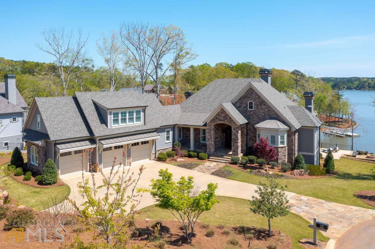 YOUR LAKE PARADISE AT HORSESHOE BEND IN REYNOLDS! MAGNIFICENT INFINITY POOL, AMAZING LAKE VIEWS FROM NEARLY EVERY ROOM OF THIS CUSTOM HOME FINISHED IN 2019! Imagine yourself waking up to the most spectacular views of Lake Oconee every day! Finished in 2019, this 6,100+ sq ft, five bedroom, five and a half bath showstopper is packed with luxurious resort features: infinity pool with stone waterfall and spa, 190 ft of shoreline with private boat dock, large outdoor patio with pool deck, fire pit, beautifully landscaped with rock wall, located on a cul-de-sac on Reynolds' new Horseshoe Bend section. The elevation of this fantastic property gives you breathtaking water views as far as your eyes can see. Upon entering the foyer, you are greeted by lots of natural light and a gracious open floor plan with lake views, wood beams, hardwood floors, glass-enclosed library/office. The expansive great room with stone fireplace is open to the kitchen, dining room and adjacent to an extensive wrap-around screened porch overlooking the lake with grill and outdoor wood burning fireplace. The French kitchen with architectural design over range features a big island, coffered ceilings, equipped with stainless steel appliances and custom cabinetry. The Master Bedroom on the main level has extra sound proofing and the beautiful master bath features double sinks and large shower. The home boasts a spacious laundry room with custom cabinets, powder room and expanded three-car garage. Large bonus room above the garage features a full bathroom, walk-in closet and a linen closet. There is an elevator that takes you to the terrace level where a large den and recreation room overlooking the pool and the lake will captivate you, complete with a wet bar, sink, ice maker. Three bedrooms with walk-in closets and en-suite bathrooms are also on the terrace level. There is also a large storage area, cedar closet and second washer/dryer hook up. The beautifully manicured backyard offers unparalleled views, with walkway, stone steps to your boat dock. The home offers extensive outdoor lighting system, outdoor security cameras, irrigation system. Ideally located within boating minutes to The Ritz-Carlton, Richland Pointe, Great Waters and other amenities. Membership available.