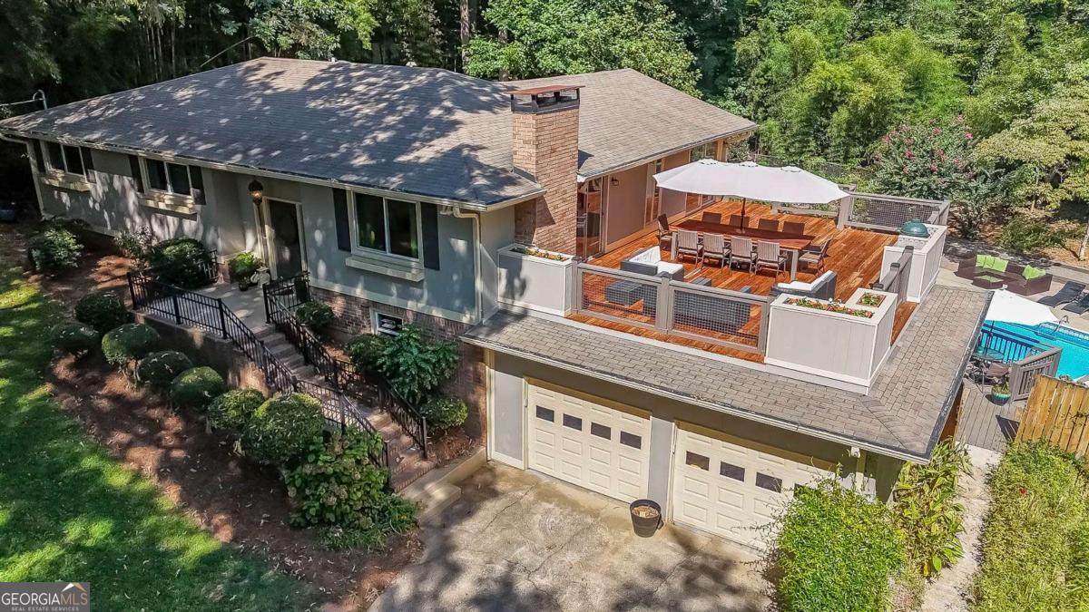 This one is the perfect combination of warm and charming indoor space and amazing outdoor living. The lot has wonderful privacy with a natural side yard with mature trees and plantings and a garden of wildflowers leading to the backyard where the inground pool sits surrounded by beautiful landscaping and a beautiful pergola. The decking that surrounds the pool includes a covered deck with a cozy sitting area, open deck area for grilling, a more secluded area with a hot tub and sitting area, and then the most amazing rooftop deck overlooking the property you could imagine complete with planting boxes and built in smoker station. The interior of the home is so charming with multiple common areas including a fireside family room with built in bookcases and a sunroom. There are 3 bedrooms on the main level and a basement with a newly finished full kitchen, an office that could be utilized as a 4th bedroom, and a full bathroom. No carpet anywhere and tons of natural light flowing in. Outbuilding on property for storage. Wonderful community with no HOA and a picturesque lake across the street from the property. Great schools and access to all highways. This property is more than a house, it is truly a retreat!