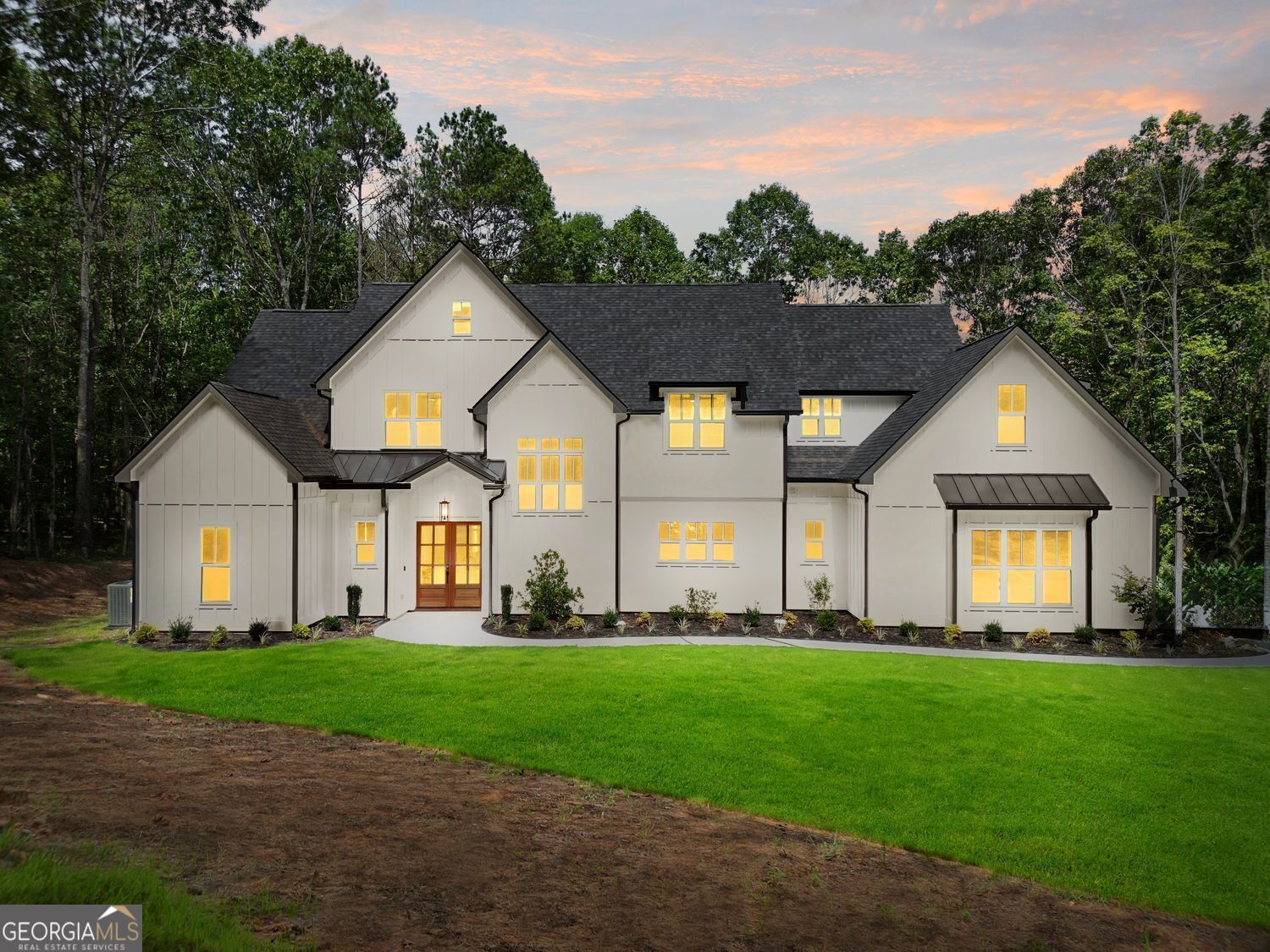 UP TO $8,500 BUYER INCENTIVE USING PREFERRED LENDER. Custom-Designed Retreat on 5.29 Acres - Set on a private, wooded 5.29-acre lot, this custom-designed 5 bed, 4.5 bath home blends modern comfort with peaceful paradise-just 25 minutes from Atlanta. A long, scenic driveway leads to your own secluded sanctuary, designed for space, flexibility, and style. Inside, natural light pours through oversized windows, highlighting an open-concept layout, soaring ceilings, and upscale finishes throughout. The chef's kitchen features quartz counters, a large island, custom vent hood, walk-in pantry, and direct access from the 3-car garage for easy unloading. The main-level primary suite offers forest views and a spacious retreat, while a second en suite bedroom on the main is ideal for guests or multigenerational living. Upstairs includes three more bedrooms-two with en suite baths-plus a versatile flex space for work or play. Out back, the covered patio invites you to relax, entertain, or unwind by the firepit under the stars. If you've been looking for a home that offers space to grow without giving up modern design or convenience-THIS IS IT!