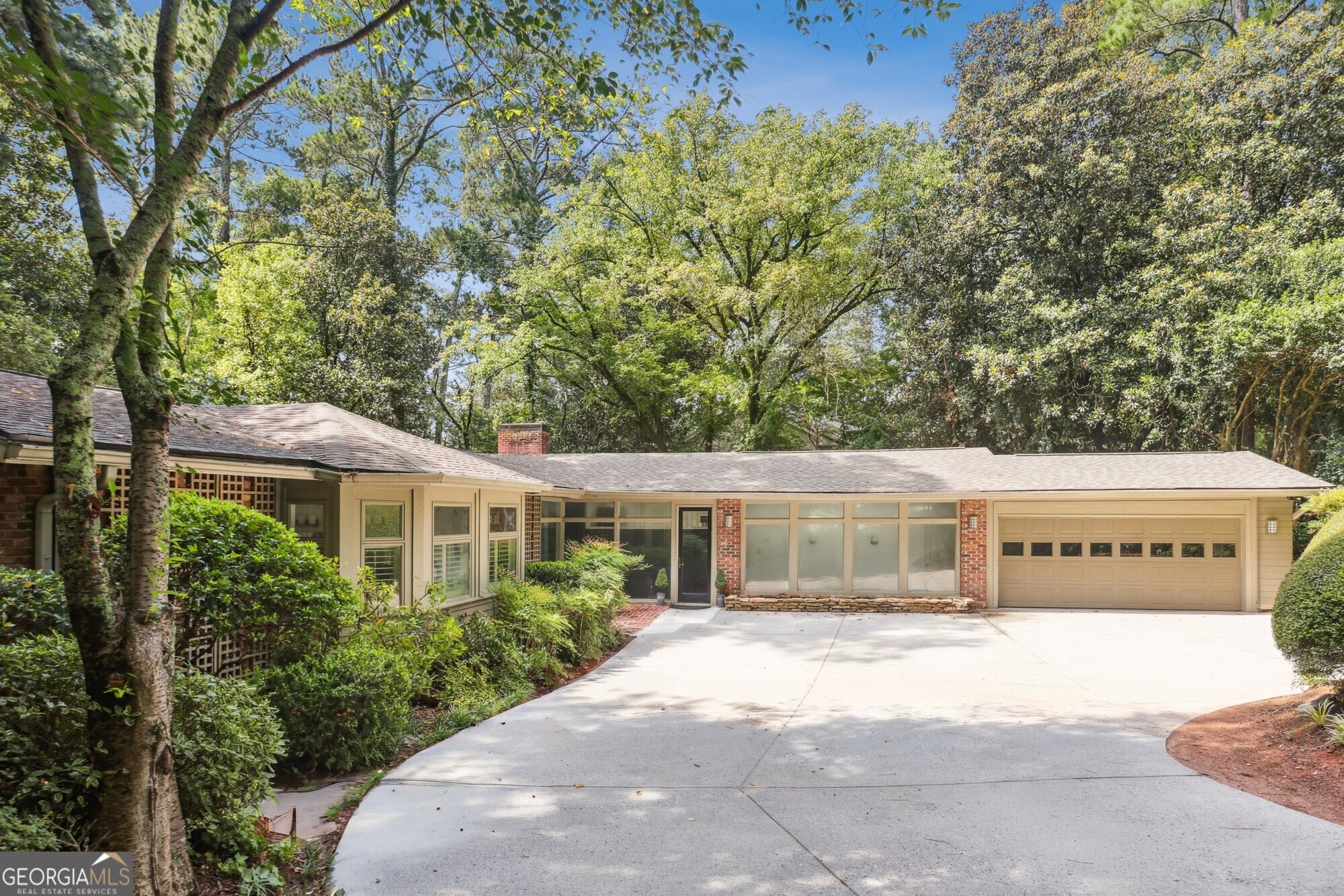 Stylish mid-century modern ranch close to Jackson Elementary and Chastain Park. Situated on a large, private lot, this 4-sided brick home features 3 bedrooms and three full baths with a bonus room that can also be used as a bedroom. Thoughtfully designed with hardwood floors throughout, this home is filled with natural light from expansive windows that bring the outdoors in. Exposed brick walls and clean architectural lines create warmth and character, while open living spaces make it ideal for both everyday living and entertaining.