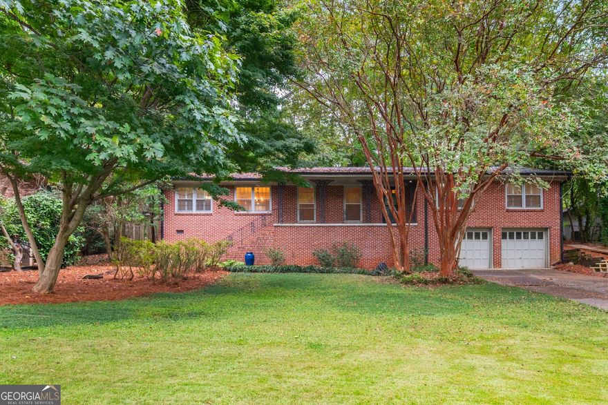 Tucked away on a quiet, tree-lined street, this stylishly remodeled mid-century home offers the perfect blend of modern updates and timeless charm. With spacious indoor and outdoor living across two levels, you'll love calling this place home. The stunning kitchen is a showstopper - featuring a mile of granite countertops throughout, a dramatic waterfall-edge island, a ton of prep space for holiday meals, and brand-new stainless steel appliances. Enjoy your morning coffee at the breakfast bar or in the cozy eat-in kitchen. The main level features four bedrooms, including two luxurious primary suites - ideal for guests, multigenerational living, or a dedicated home office. Step out to the screened-in porch for year-round enjoyment and views of the expansive, private backyard - perfect for gardening, entertaining, or simply relaxing. Downstairs, the terrace level boasts a massive family room with built-in shelving - easily large enough to divide into multiple spaces or add an additional bedroom. A spacious two-car garage provides abundant storage. This move-in-ready home combines comfort, space, and location - just minutes from Emory, the CDC, and three parks.