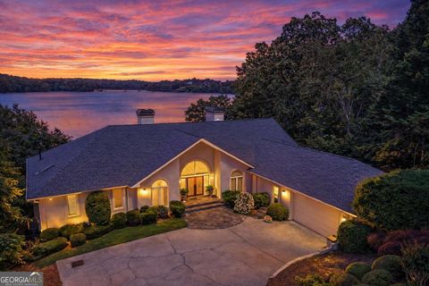 Stunning lakefront home at sunset with panoramic water views, modern architecture, and landscaped yard, showcasing the tranquil lifestyle near Lake Lanier.