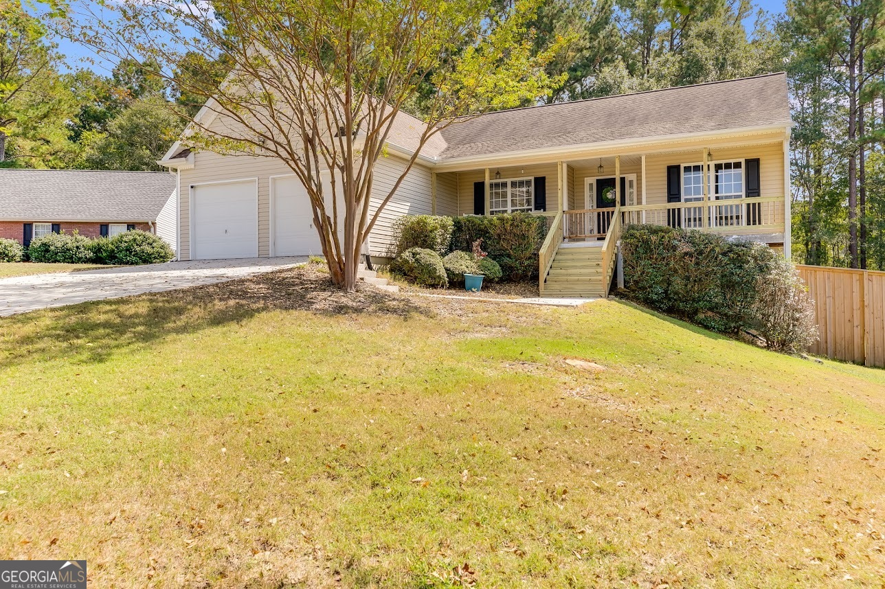 Welcome to this charming one-owner ranch home, ideally situated in a quiet cul-de-sac within a welcoming neighborhood, offering a sense of privacy while still enjoying the benefits of a community setting. The home features a spacious covered front porch, perfect for relaxing outdoors, and an extended rear deck designed for entertaining or unwinding in the fully fenced backyard. The basement is a mechanic's dream, matching the square footage of the main living area and providing ample space for projects, with power and a breaker box ready to accommodate a large air compressor. The main two-car garage, 19'6" deep by 12' wide, easily accommodates two full-size short-bed quarter-ton trucks and includes convenient LED Chamberlain Bluetooth garage door openers. Inside, modern conveniences include an updated Bluetooth thermostat, a gas tankless water heater for endless hot water, and a recently replaced waterline from the street to the house. Fiber internet is available through Greystone Connect, with wiring already run from the exterior to the living room. The home comes fully equipped with appliances, including a washer, dryer, refrigerator, and a convection air fryer microwave. The kitchen has been thoughtfully updated with beautiful wood flooring installed less than three years ago, a subway tile backsplash, a motion-activated faucet over a white cast iron sink, and a whisper-quiet garbage disposal. Bedrooms feature new carpeting installed within the past three years, and the entire interior has been freshly painted for a move-in-ready appearance. Cozy up in the living room next to the wood-burning fireplace, ideal for relaxing evenings. Outside, the manicured front lawn showcases seven recently planted holly trees along the property edge, two mature crepe myrtles, and is further enhanced by a young Japanese maple and an evergreen dogwood, adding charm and curb appeal. With its thoughtful interior updates, spacious living areas, functional garage and basement, and a quiet cul-de-sac location, this home offers a rare opportunity to enjoy comfort, convenience, and a private, yet connected, neighborhood lifestyle in one exceptional property.