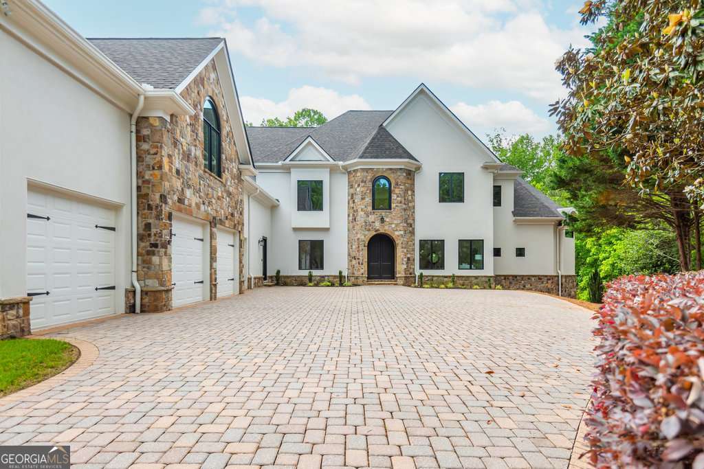 Welcome to modern, luxury riverfront living on the banks of the Chattahoochee within the prestigious gated golf course community, Country Club of the South. 500 Covington Cove is more than just a home - it is a truly unique lifestyle surrounded by nature with contemporary design and architecture. It has been completely reimagined from top to bottom with the highest quality materials and details. One of only four homes with direct gated river access, this home offers an exclusive opportunity for those searching for a sophisticated home with unbeatable panoramic views. Situated on a cul-de-sac lot, the home is private but offers a grand first impression with a 4-car garage and European style stone facade. The kitchen is a showpiece of the home, featuring Miele appliances throughout, including a paneled refrigerator/freezer, regular oven, steam oven, and speedy oven. Custom cabinetry by The Furniture Guild adds a touch of luxury, with 8 double, lighted-glass & metal 8-foot doors, built-in utensil and knife drawers, and recessed spice/utensil racks flanking the cooktop. The quartzite countertops and backsplash, along with the oversized island, provide ample space for meal preparation. The double sink with a work station, dual sink faucets, and instant hot tap make kitchen tasks simple and luxurious. A butler's pantry adds additional storage and functionality. The large primary suite brings in stunning natural light and feels like a retreat with panoramic views of the river year round. The flooring features site-finished white oak wide plank flooring, adding a touch of sophistication to the space. Structural improvements have transformed the living space, which is ADA compliant, along with many other areas of the home. Upstairs, you'll find a new ADA-compliant ensuite bathroom with marble finishes and a skylight, as well as a shared ADA-compliant bathroom. TOTO toilets have been installed throughout the home for added convenience. New carpet has been installed in the upstairs bonus room for added comfort. A brand new elevator services all floors of the home including the large finished daylight basement complete with everything you could imagine! Climate controlled 242-bottle capacity wine cellar, full wet bar, exercise room, multiple living spaces, 2 bedrooms, 2 full bathrooms, and 1 half bathroom. Terrace level walks out to the heated, salt-water zero entry pool and spa overlooking the large backyard and sport court. With direct, gated access to the river you can enjoy all that waterfront living offers year round. Major structural improvements have been made to improve the functionality of the home, add square footage, and introduce energy efficiency with the highest quality materials and products available. Brand new Windsor Pinnacle windows throughout prioritizing temperature control and efficiency. They also prevent fading on your furniture, drapes, and flooring with reduced UV light penetration allowing you to enjoy tons of natural light without worry. Efficient thermostats and spray foam insulation have also been installed for ultimate comfort. Seclusion and luxury all located just minutes from top rated schools (Johns Creek High School, Wesleyan, GAC, and more), shopping, and the city. Immerse yourself in the unparalleled lifestyle that awaits you at 500 Covington Cove.