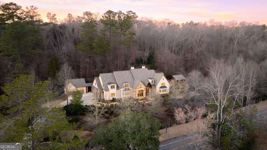 Nestled on over two acres of exquisitely landscaped grounds, this European-inspired estate, crafted by renowned builder Lawson Calhoun, epitomizes quality and craftsmanship. Situated in the prestigious East Cobb community, the residence boasts impeccable materials and unparalleled attention to detail. Gas lanterns frame the solid double doors, leading into a grand two-story foyer with a sweeping staircase. Rich hardwood floors and soaring 12-foot+ ceilings enhance the homeCOs elegance. The magnificent great room, with vaulted wood beam ceilings and a grand fireplace, seamlessly connects to the chefCOs kitchen. This professional-grade space features a Viking 6-burner double oven range, Fisher & Paykel dishwasher drawers, Sub-Zero refrigerator, wine cooler, microwave drawer, and polished nickel fixtures. The Calcutta Gold backsplash, granite countertops, and informal dining area further elevate the kitchen. A lodge-style screened porch with a fireplace and stone patio offers a serene retreat. Nearby, a mudroom includes a junior office, spacious laundry room, and granite-topped cabinetry. The dramatic two-story dining room showcases floor-to-ceiling paneling and a hand-painted ceiling, while the formal living room, with a coffered ceiling and elegant fireplace, provides another inviting space. The primary suite is a spa-like sanctuary, featuring a freestanding soaking tub against a custom tile wall, a walk-in shower with dual heads and seating, double vanities, two commodes, and two expansive California Closet-designed walk-ins. A custom-painted ceiling dome and wood beam accents add to its charm. Upstairs, a loft-style landing with hardwood floors serves as an office, study, or gallery space. Four spacious ensuite bedrooms, each with custom closets, are complemented by a secondary laundry room for convenience. The terrace level is an entertainerCOs dream. High ceilings and hardwood floors set the stage for a coffered ceiling media room with direct access to the side green space and pool area. A large game room, a well-appointed beverage center with granite counters, refrigerator, and dishwasher, a full-size gym with mirrored walls and sauna, an extensive craft room with custom cabinetry and a central island, and a spacious sixth ensuite bedroom complete this level. The WALK-OUT FROM MAIN LEVEL resort-like backyard exterior boasts two expansive green spaces, serene waterfalls, and a pond. A heated in-ground pool with sundeck and fountains creates a private oasis. The adjacent cabana features Trex flooring, an outdoor kitchen with an ice maker, refrigerator, grill, outdoor TV, and a full bathroom, shower, and firepit. Car enthusiasts will appreciate the two separate garages: an attached three-car garage with new epoxy flooring and a detached, heated, and cooled garage with a bathroom, work sink, 80-gallon compressor tank, and air pressure connections. This space accommodates at least two cars, with one bay designed for a lift. Fully fenced and gated for privacy and security, this estate is located in the highly sought-after Sope Creek, Dickerson, and Walton school districts within the ATLANTA COUNTRY CLUB  area. With top-tier systems and impeccable maintenance, this home offers an unparalleled lifestyle of elegance, comfort, and convenience in one of Cobb CountyCOs most desirable locations.