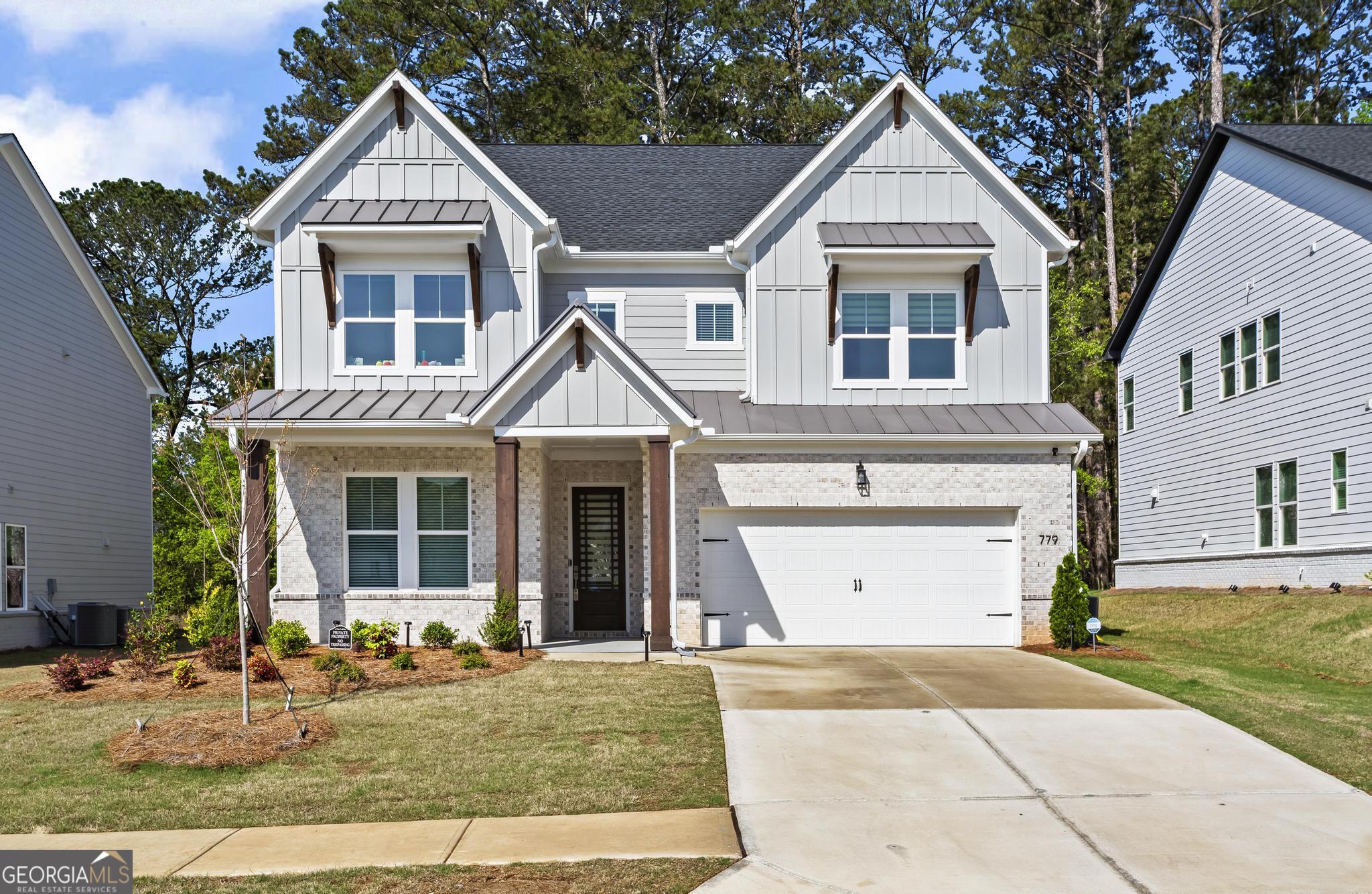 MOVE-IN READY! $5,000 towards closing costs with our preferred lender. Why wait to build when you can move right into this stunning, like-new home packed with upgrades throughout? Like-new modern "Serenity" farmhouse with premium upgrades, located in the desirable Vista Ridge community. This spacious 5-bedroom, 4-bath home offers an open-concept layout with a modern chef's kitchen featuring a massive eat-at island, double ovens, gas cooktop, stainless steel appliances, sleek quartz countertops, tile backsplash, microwave, vent hood, coffee/dry bar, extra cabinetry, walk-in pantry, with access and view of nature private from your covered patio. The main level includes hardwood floors throughout, a private guest/in-law suite, a dedicated home office, and a drop zone/mudroom off the garage entry. The family room features a gas fireplace and flows seamlessly to the dining area, perfect for entertaining. Upstairs, you'll find a large loft/bonus/media room, generous secondary bedrooms with walk-in closets, and a spacious primary suite with a spa-like bathroom including dual vanities, a double shower with bench, plenty of natural light, and large his-and-hers walk-in closets. Upstairs also includes the laundry room with extra cabinets and a laundry sink. Additional features include upgraded flooring, modern lighting, and custom window treatments. Enjoy the private wooded view from your covered patio. Located just minutes from Downtown Woodstock, top-rated Cherokee County schools, parks, shopping, dining, and easy access to I-575 and North Fulton