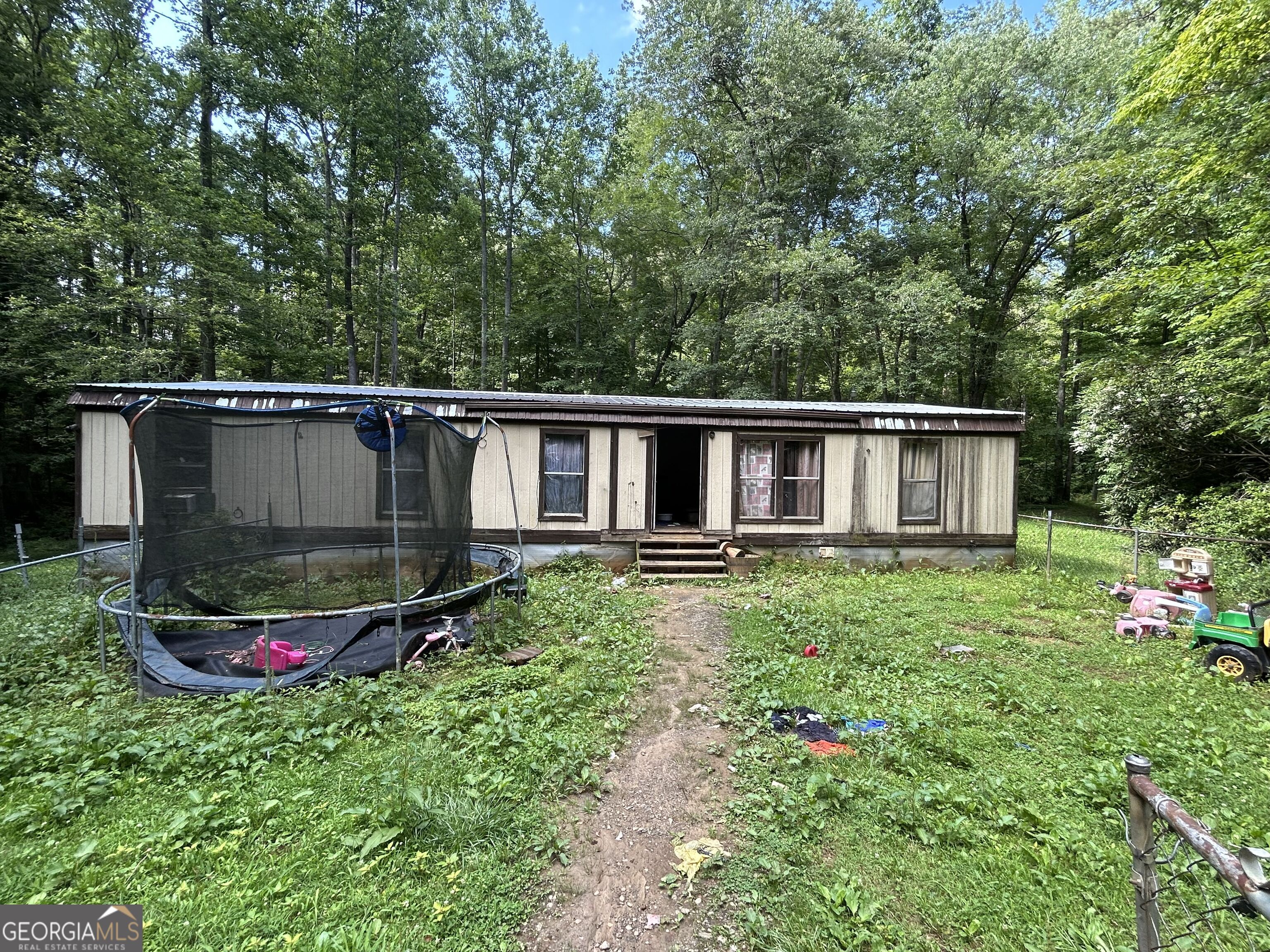 Charming 2 bed, 2 bath double-wide manufactured home on a peaceful lot, perfect for someone seeking a quiet retreat with room to personalize. Featuring a 9-year-old roof, original windows, and durable laminate flooring, this home offers solid bones and plenty of potential. Stay cool with window AC units, and enjoy the convenience of well water. The property includes a shed for extra storage and sits on a crawlspace foundation with no known issues. While the kitchen, bath, plumbing, and electrical systems are original and ready for your updates, this home presents a great opportunity to create your own vision in a serene setting.