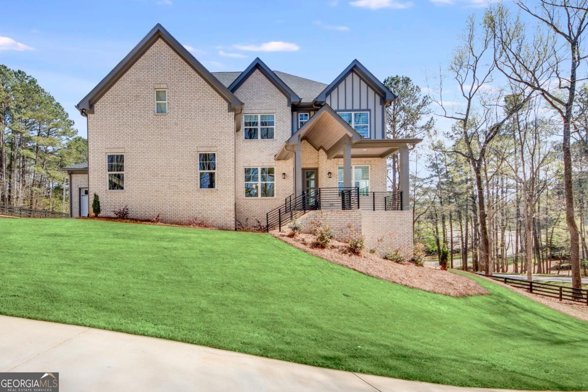 Luxurious Contemporary Modern four-sided brick Home over a Full unfinished BASEMENT fully fenced lot with an oversized parking pad and overside covered custom-made porch, deck with gas line for grill. This gorgeous open-floor plan home features 5 bedrooms and 4.5 bathrooms, a trey ceiling, a Master Bedroom with a massive closet, hardwood floors throughout the entire house, a big open kitchen w/oversized island, and quarts countertops, high-end SS appliances with unique finishes, high-efficiency HVAC, and 3-car oversized garage and 2nd Family Room with a custom-made fireplace on the 2nd floor, over a full unfinished basement. The 1st level features a guest suite, bedroom with a private bathroom, office, family room with custom-made fireplace. The oversized Owner's Bedroom sits on the upper level, an oversized custom-built bathroom with a double vanity, a separate tile shower, and a freestanding soaking tub. Also, the oversized owner's walk-in Closet w/2 additional storage features modern custom cabinetry. Additional features include a covered porch, patio, gourmet stainless steel appliances, upgraded exterior and interior paint. Enjoy your morning coffee on your covered backyard patio, front porch, offering future owners comfort and privacy. Water treatment and softener full house and alkaline drinking water. Camera system included. Conveniently located close to I85, hwy 316, and to Mall of Ga. Great school district, restaurants and shopping, NO HOA. This home has high-end finishes and is a MUST-SEE Collins Hill High School cluster home.
