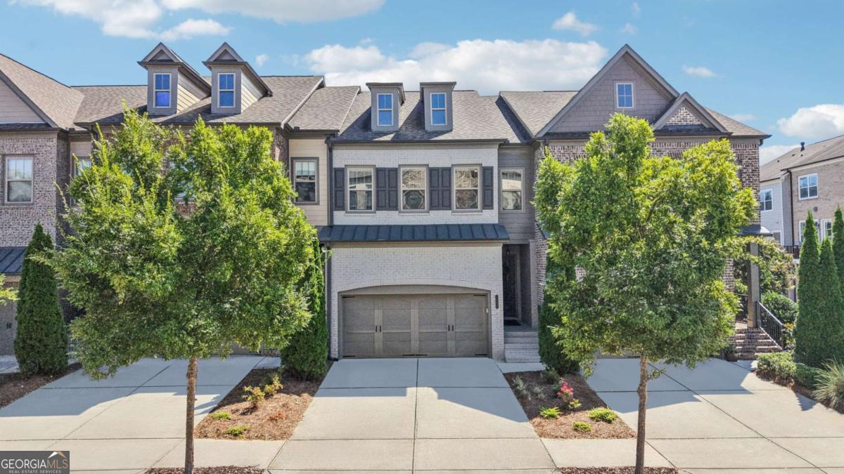 Beautifully maintained 3-story townhome in the highly sought-after gated Harlow community, located in the top-rated Milton High School district. This desirable floor plan offers 3 bedrooms, 3.5 bathrooms, and multiple outdoor living spaces. One of the standout features is the easy access from the garage directly onto the main level-no need to haul groceries up a full flight of stairs like in many other three-story townhomes. The driveway provides parking for additional cars, which is a valuable convenience in townhome living, and there's no shortage of guest parking with several spaces located just steps away. Inside, enjoy hardwood floors on the main level, where the light-filled living room with a cozy fireplace flows seamlessly into the open kitchen featuring quartz countertops, a large island, and stainless steel appliances. Step outside to the deck for effortless entertaining. Upstairs, the spacious primary suite offers abundant closet space and a spa-like bath with a soaking tub, dual vanity, and separate shower. Two additional bedrooms, a full bath, and the laundry room complete the upper level. The finished terrace level adds flexibility with a full bathroom and access to a fenced backyard and patio. Harlow is known for its vibrant, active community, offering year-round social events and an array of resort-style amenities including two pools, tennis and pickleball courts, bocce ball, dog parks, green spaces, ponds with walking trails, and a fantastic clubhouse. HOA dues cover lawn and landscaping maintenance, exterior structure upkeep, trash service, and termite treatment, making for low-maintenance living. Ideally located within walking distance to Ameris Bank Amphitheatre and just minutes to Avalon, downtown Alpharetta, North Point Mall, and GA-400, this home offers the perfect balance of convenience and lifestyle.