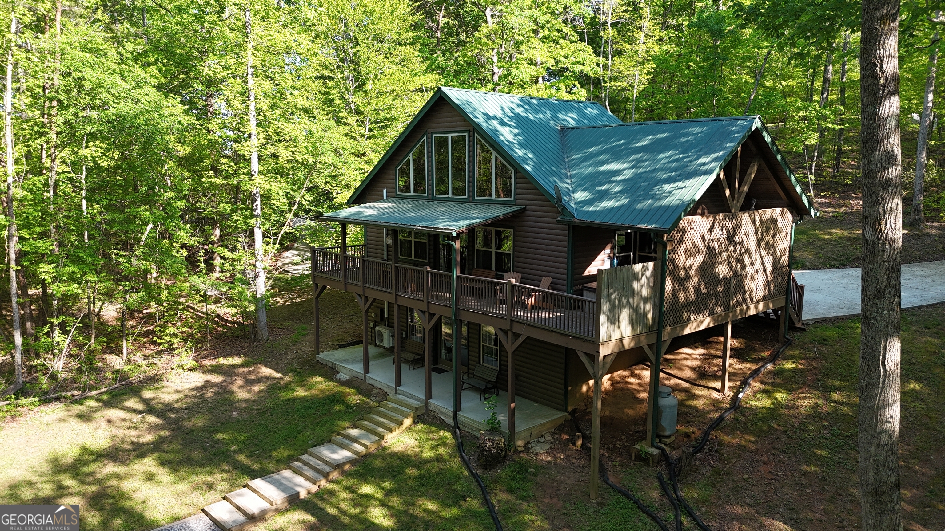 Tucked away in a secluded area is this stunning cabin that seamlessly blends modern sophistication with rustic charm and offers an unforgettable escape for those seeking relaxation and adventure. Located near the charming town of Helen, in the beautiful North Georgia mountains, outdoor enthusiasts will delight in activities such as fishing, tubing, hiking, horseback riding, and ziplining. The area is also rich in cultural offerings, featuring festivals, unique shops, dining, vineyards, and craft breweries, making it a hub for those seeking diverse experiences. While officially listed as a 2-bedroom cabin, the innovative "open design" of the lower level transforms this cabin into a spacious 4-bedroom sanctuary. The spacious, fully equipped kitchen boasts upgraded appliances, solid surface countertops, and high-end finishes. The master suite is a haven of luxury, featuring an oversized walk-in shower, a separate whirlpool tub to relax and unwind. The lower level features two pod beds with privacy curtains, twin-sized bunk pod, ensuring comfortable accommodations for everyone. A spa-like bathroom adds a touch of luxury to the downstairs space. For families, the lower level becomes a playground with pool, board games, cornhole, and a TV area, ensuring entertainment for all ages. Downstairs you will also find the convenience of the washer/dryer and a bar area with sink. Step outside onto the spacious deck and sink into the hot tub for an evening of relaxation under the stars. The deck features a comfortable covered sitting area. The downstairs opens to a patio for entertaining... Whether it's roasting marshmallows by the fire, snuggling up to a good book, or exploring the area's abundant outdoor activities, this cabin is a gateway to both relaxation and adventure. This turn-key cabin is perfect for a full time residence, second home, or income-producing rental property. Don't miss the opportunity to make this tranquil retreat your own.