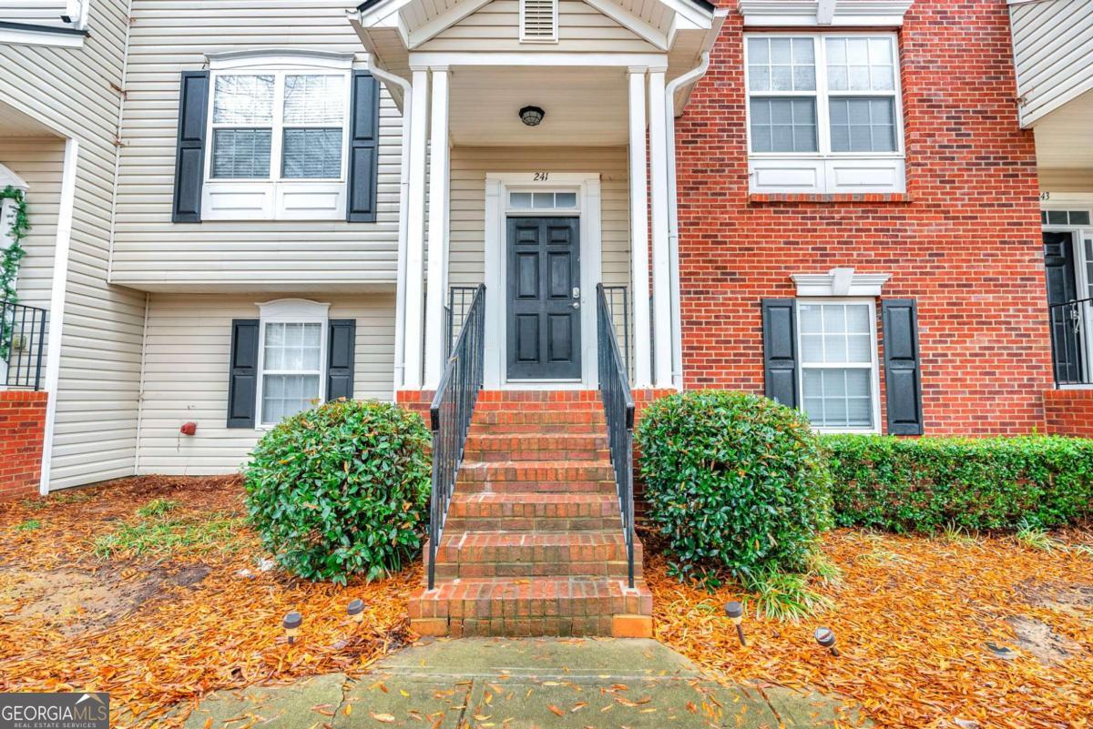 Move-In Ready Townhome - Prime Woodstock Location! Immaculate 3-bedroom, 2.5 bath townhome in sought-after community with pool, tennis, playground, and walking trail. Open-concept main level with hardwood floors, spacious family room, dining area, kitchen, and flex space/office. Freshly painted interior, new carpet, granite counters, and upgraded lighting throughout. Owner's suite features walk-in closet with custom organizer and private bath. Laundry is conveniently located upstairs. The third bedroom on the lower level is perfect for guests, an office, or a media room. Private deck backs to the retaining wall for added privacy. 2-car garage with SUV space plus guest parking nearby. Grounds maintenance and trash service are included. Minutes to schools, Target Shopping Center, The Outlet Shoppes, dining, and entertainment. Easy access to Roswell, Marietta, Downtown Woodstock, I-575, and GA-400.