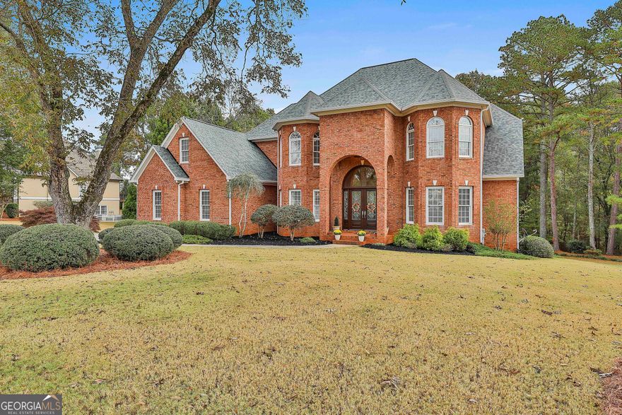 Exquisitely designed 4-sided brick Southern Living masterpiece in sought after Lake Park in Sharpsburg! This stunning custom home with professional landscaping sits on a beautiful 1.6 acre lot with mature shrubs and trees. Before stepping inside this spectacular home, you'll notice the beautiful lead glass double entry doors...the grand entrance creates an impressive and memorable first impression! While you may prefer guests to enter through the front, a separate side entrance with a covered porch is perfect to bring groceries in during a rainy day and drop your shoes in the mud room. The two story foyer opens to the custom winding staircase with a view into the elegant but comfortable family room with it's richly-appointed spaces including the fireplace with built-ins attached.   The formal dining room, complimented by a convenient butler's pantry, sets the stage for sophisticated entertaining, while the kitchen and keeping room serve as the heart of the home, designed with the serious culinary enthusiast in mind and outfitted with professional-grade appliances, new Quartzite countertops and bespoke finishes.  The bright kitchen and keeping room overlook both the deck and the serene back yard which serves as the perfect spot for a morning coffee and offers year-round indoor-outdoor living.   Custom High End Cabinetry and Custom High End Trim work throughout creates a sense of understated grandeur.  The master suite is a private sanctuary on the main floor with a flex room attached.  This space is currently used as an office but could serve many purposes including a sitting room or additional walk-in closet (for those with endless shoes and clothing.)  A cozy fireplace warms the master bedroom (w/coffered ceiling) and master bathroom during the cooler months.  When it's time to relax,  the spacious master spa tub with jacuzzi jets is the perfect spot with a reversable tv over the fireplace.  Separate his and hers master closets and vanities and an octagon-shaped lighted ceiling feature in the master bathroom gives it an elegant feel.    Upstairs includes 2 additional bedrooms sharing a full bath and double built-in desks in the bonus room. There is a large unfinished space for future den/game room above kitchen.  A third upstairs bedroom, along with a ensuite bathroom, complete this floor.  The finished terrace level reveals gorgeous lvp flooring and a casual ambiance ideal for entertaining and game day. This level with a second kitchen and full bath, one room which can serve as a bedroom, is equipped to serve the demands of modern living as an in-law suite, space for adult children, or as rental income. No detail has been overlooked in engineering both beauty and resilience into the home's core infrastructure. With comprehensive system replacements, this residence functions as a brand-new home.  New roof in 2025, two water heaters with auto leak shutoff to never a worry of running out of hot water or flooding basement (one replaced in 2014, one replaced in 2019.)  In addition to the two car garage on the main level, there's a 17x40 unfinished area in the basement with 9 foot roll up garage for golf cart, work shop, etc.    Sprinkler system is in both the front and back and the septic system in front yard for the possible future in-ground pool.   The expansive back yard includes a large patio area under the deck/covered porch and remains private and wooded with a small creek along back of property.  There is a 5x10 concrete safe room under the front porch to keep family safe during our stormy season.  Convenient to the airport, I-85, both Fayette Piedmont and Newnan Piedmont Hospitals and the City of Hope.  You'll appreciate the short drive to Peachtree City, Senoia, and downtown Newnan for plenty of shopping and restaurants.