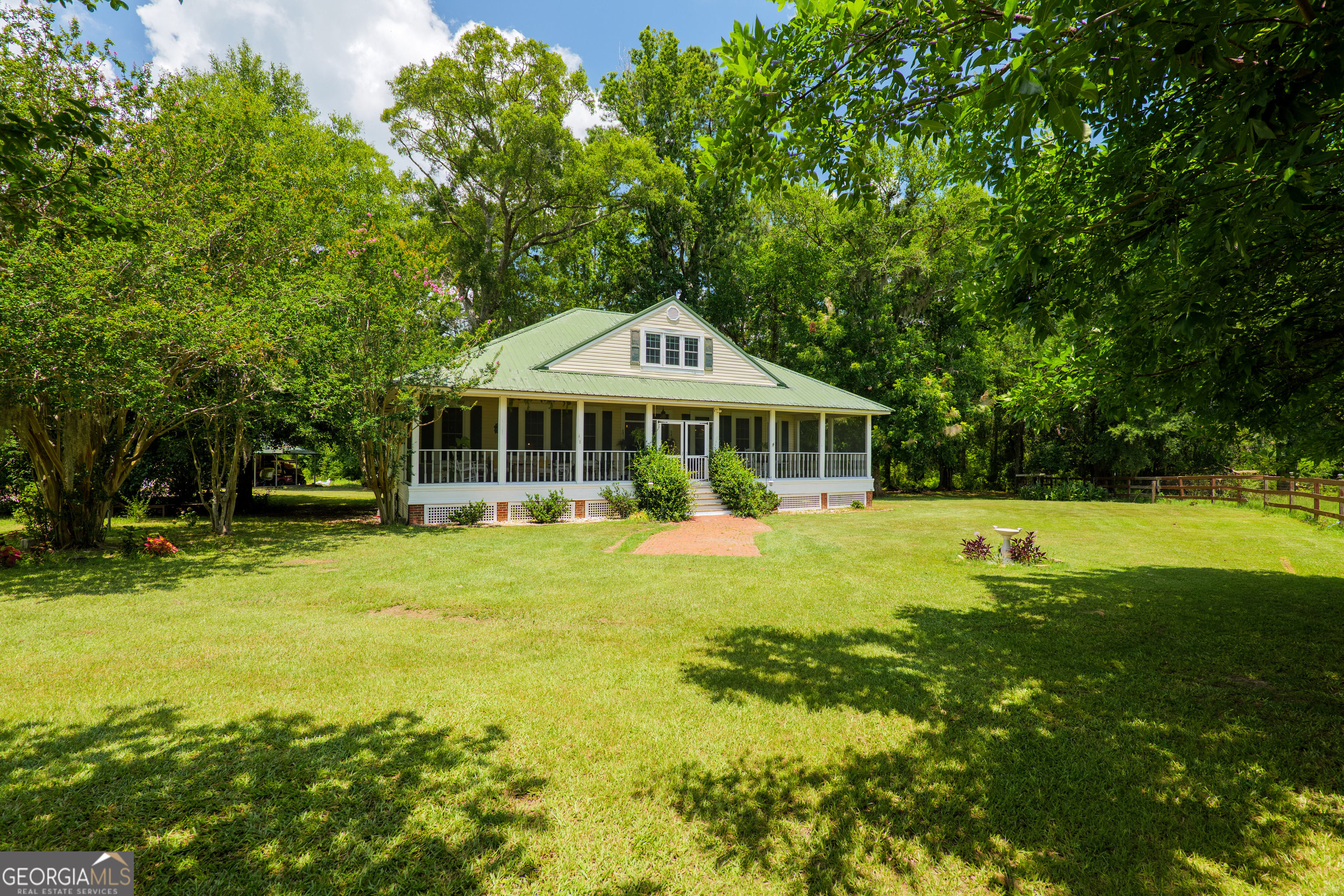 Welcome home to paradise in South Georgia! This stunning farmhouse, nestled on just over 7 private acres, radiates peaceful living. Upon arrival, you'll be greeted by an absolutely massive wrap-around porch, offering the perfect setting for enjoying the tranquility and privacy of your expansive property. Inside, discover nearly 3,000 sq ft of beautifully updated living space. A spacious foyer welcomes you, flanked by a formal dining room on one side and a versatile bonus space on the other - ideal for a second living area, home office, or gym. The oversized main living room boasts lovely Spanish tile floors and a cozy fireplace, creating an inviting atmosphere. Preparing meals is a delight in the chef's kitchen, featuring abundant counter space, granite countertops, stainless steel appliances, and a gas cooktop. The main level also includes a convenient half bath within a large laundry room. Your owner's suite, a private sanctuary, is also located on the main floor, complete with a beautifully updated ensuite. Indulge in the charm of shiplap walls, a classic claw-foot tub, a refreshing tile shower, and dual sinks. Upstairs, two additional bedrooms share a spacious Jack-and-Jill bathroom, and a versatile bonus space offers potential for a fourth bedroom or other needs. Gorgeous reclaimed heart pine floors flow throughout the living areas and bedrooms, adding warmth and character. Outside, endless possibilities await on your vast acreage, perfect for spreading out and enjoying the beautiful South Georgia countryside. A wired workshop with covered parking provides extra utility. This dream home is zoned for Hahira Elementary/Middle and Lowndes High and is conveniently located just minutes from I-75. Don't miss your chance to own this exceptional property - call today to schedule your private tour!