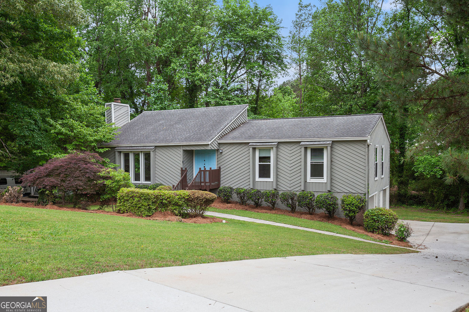 Welcome to this spacious and light-filled 4-bedroom, 2-bath home that combines comfort, style, and functionality. From the moment you arrive, you'll be impressed by the gorgeous landscaping and inviting curb appeal. Step through the foyer into a large living area flooded with natural light, thanks to floor-to-ceiling windows that bring the outdoors in. A cozy fireplace adds warmth and charm, making it the perfect gathering space year-round. The main-level primary suite offers privacy and relaxation with its own ensuite bathroom and a generously sized walk-in closet. The heart of the home is the kitchen, featuring a sunny breakfast area, along with both formal and informal dining spaces-ideal for entertaining or everyday meals. The formal dining room opens directly to the back deck, overlooking a private, beautifully yard. Downstairs, the basement offers incredible bonus space, including a large flex room perfect for a game room, media space, or home gym. An additional bedroom with a window could serve as a guest room, office, or hobby space, and there's also a large storage closet for extra organization. The oversized garage is a dream for anyone who needs space, with ample room for storage, a workbench, or even a small workshop. This home has it all-room to grow, space to entertain, and a peaceful setting you'll love coming home to.