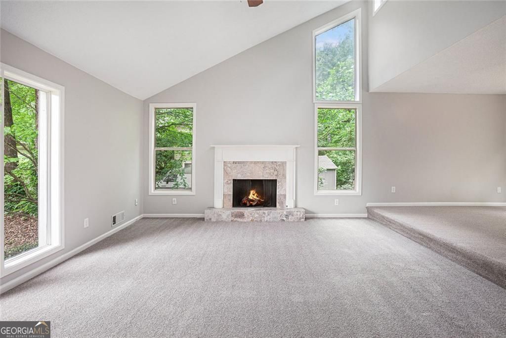 Welcome to this spacious and light-filled 4 bedroom, 2 bath home that combines comfort, style, and functionality. From the moment you arrive, you'll be impressed by the gorgeous landscaping and inviting curb appeal! Step through the foyer into a large living area flooded with natural light, thanks to floor-to-ceiling windows that bring the outdoors in. A cozy fireplace adds warmth and charm, making it the perfect gathering space year-round! The main-level primary suite offers privacy and relaxation with its own ensuite bathroom and a generously sized walk-in closet. The heart of the home is the kitchen, featuring a sunny breakfast area, along with both formal and informal dining spaces-ideal for entertaining or everyday meals. The formal dining room opens directly to the back deck, overlooking a private, beautifully yard. Downstairs, the basement offers incredible bonus space, including a large flex room perfect for a game room, media space, or home gym. An additional bedroom with a window could serve as a guest room, office, or hobby space, and there's also a large storage closet for extra organization. A brand new AC has just been installed, offering added comfort and energy efficiency year-round. The oversized garage is a dream for anyone who needs space, with ample room for storage, a workbench, or even a small workshop. Neighborhood has an optional HOA with Tennis and Swimming Pool. This home has it all-room to grow, space to entertain, and a peaceful setting you'll love coming home to. Up to $21,945 in Down Payment and Closing Cost assistance with preferred lender.