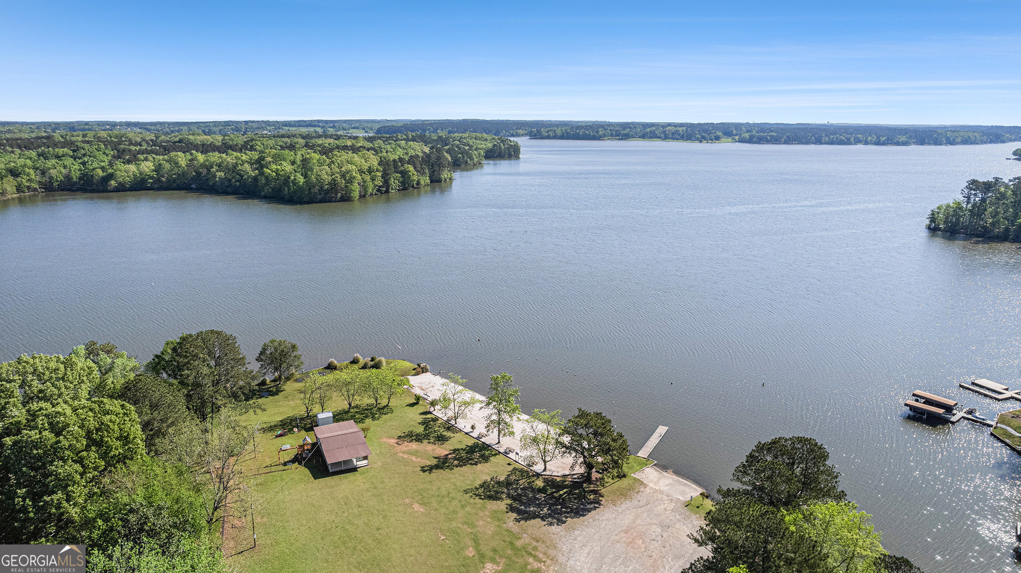 Don't miss this unique opportunity to own a fee simple lot in the desirable Sugar Creek Farms community, offering private access to Lake Oconee and a host of amenities for lakeside living. This property includes a 1999 Sunnybrook fifth wheel camper, enclosed porch, and a spacious 28x30 ft carport, making it the perfect getaway or full-time retreat, along with this property having it's own septic tank! Whether you're enjoying your morning coffee on the porch or launching your boat for a day on the water, this place has it all. The community features a private beach, a fishing pier, boat tie offs at the sewall, covered pavilion, and community bath houses! You will not find a better deal that gives you direct access to Lake Oconee! Whether you're an avid boater, a weekend fisher, or just looking for a peaceful escape near the lake, this property has everything you need to enjoy the Lake Oconee lifestyle without breaking the bank!