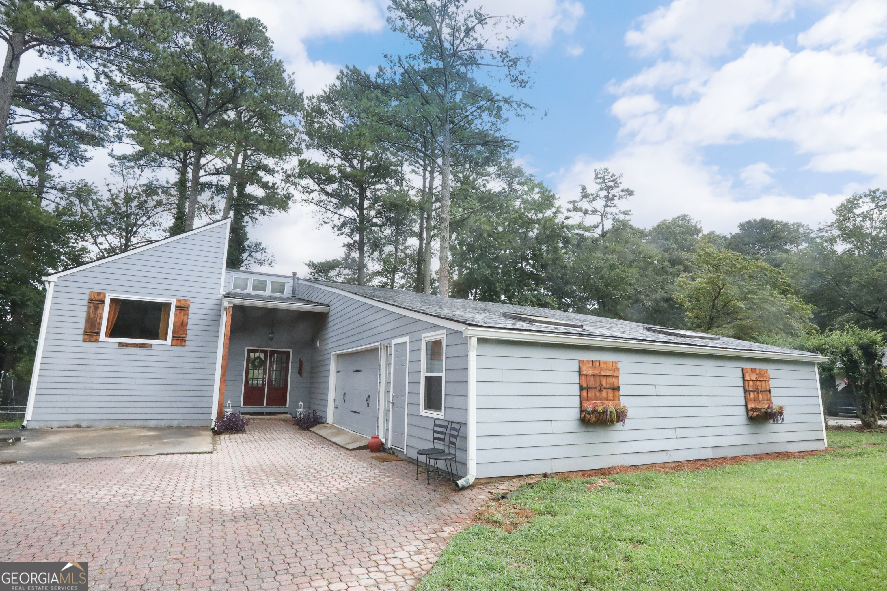 This amazing home in the perfect location will provide everything your family needs. This 3-bedroom, 2-bath home in desirable Marietta, Georgia is light & bright from the moment you are welcomed into the foyer through the beautiful all wood double front doors. The beautiful view into the private large back lawn greets all your family and friends. This remodeled & updated home has all of the upgrades for comfortable living. The stylish kitchen with all the extras is a chef's dream with plenty of cabinets and counters, a space for dining and even a keeping room if desired. View the outdoors from every area of your living space. Huge, open kitchen & dining area looks out to the wall of windows in the family room facing your backyard. Cozy fireplace in the living room for those chilly evenings is complimented by the wooden beams and tons of natural light. Separate flex space can be an office, sitting room off the master, play area for kids or an area for guests with soaring ceilings & open view to living space. The flat & spacious fenced-in backyard, ideal for pets and children is wooded and private with pear trees as a bonus. Step outside onto the large patio that is perfect for fall afternoons, summer barbecues or morning coffee. The two-car garage has additional room that can be storage or even a home gym. Sought after location just minutes from Downtown Woodstock, biking distance to Nicholson Elementary School & McCleskey Middle School and the Nicholson Trail is close by!