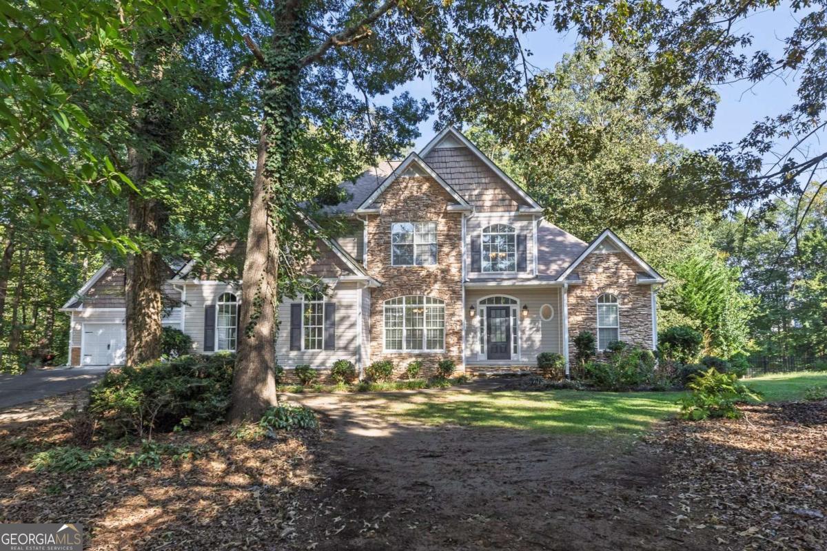Discover timeless charm and modern convenience in this traditional home in highly sought after Trace Ridge! This South Paulding 4BR/3.5BA home is set on over an acre of land. Offering a perfect blend of space and functionality, this property features a master on main, sparkling in-ground pool, ideal for outdoor living and entertaining, and an additional detached garage for ultimate versatility. Inside, the primary suite on the main level provides comfort and ease, with a luxurious bathroom with soaking tub, step in shower, double vanities and large closet. The heart of the home offers a spacious family room filled with natural light, hardwood floors and a stone fireplace. Just off the family room is a screened porch to enjoy the fall breeze or morning coffee. The kitchen is designed for both function and style, featuring ample cabinetry, prep space, breakfast bar and a seamlessly connected cozy keeping room that provides the perfect spot for relaxing by the fire or gathering with loved ones. This home also features a large dining room making everyday meals and entertaining effortless. Together, these spaces create a warm and inviting atmosphere ideal for both. Upstairs, you will find two generous size bedrooms with an adjoining bath plus a versatile bonus room offering plenty of space for family, guests, or a home office. The fully finished basement expands your living possibilities with its own kitchen, full bath, media room w/elevated seating and generous living areas-perfect for a guest suite, in-law accommodations, or recreation space. Freshly painted interior, w/2 year old roof, HVAC units on main and upstairs only 3 years old. With its spacious culdesac lot, large open layout, private acreage, and inviting swimming pool, this home offers both warmth and opportunity to create lasting memories.