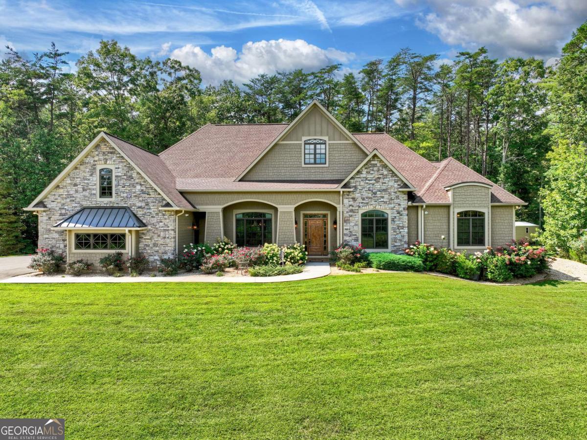 Experience refined mountain living in this five-bedroom custom-built home, perfectly positioned in the heart of the Aska Adventure Area. Showcasing timeless architecture, detailed custom millwork, and a warm, inviting design, this residence blends rustic charm with modern elegance. Set on over 4.5 acres, the property offers unmatched privacy while capturing sweeping views of the mountains and the rolling pastures of Aska Farms. Expansive windows and open living spaces frame the natural beauty, filling each room with light and serene views. The interior features thoughtfully designed living areas anchored by cozy fireplaces, a chef's kitchen ideal for entertaining, and spacious bedrooms that offer comfort and seclusion for family and guests alike. The home is being sold furnished, ready for its new owners to start enjoying immediately. Step outside to your own private retreat-an expansive covered patio with fireplace overlooking a sparkling pool. Whether you're gathering with friends, enjoying a quiet morning, or relaxing at sunset, the outdoor living spaces create the perfect setting. Despite its tranquil seclusion, this estate offers the convenience of all-paved access and is less than five minutes from the boutiques, dining, and charm of downtown Blue Ridge. Here, you'll enjoy the best of both worlds-extreme privacy with quick access to town and endless outdoor adventure right at your doorstep. A rare opportunity to own a private mountain estate that embodies timeless design, elevated outdoor living, and one of the most coveted locations in North Georgia.