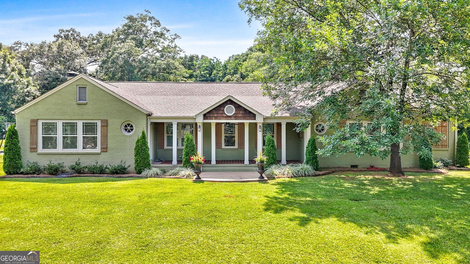 This is the Definition of a Quintessential Southern Home in the Sweet Town of Thomaston, GA! This all brick ranch offers a sprawling floorplan and was originally built in the 1940's, but has been completely remodeled with the finest finishes and updates, all while maintaining the beauty and charm of the era. Offering over 3,300 square feet, the home offers 3 spacious bedrooms and 3 full baths on the main and a HUGE finished upstairs room that is suitable for a 4th bedroom, bonus/play room, or it can be utilized as a huge walk-up attic storage space (this finished space is not included in the square footage)! The large covered front porch with tile floor & ceiling fan overlooks the lush lawn and welcomes you into the formal foyer entry of the home. Step inside to discover gleaming real hardwood floors in great condition, as they welcome you into the living space! There's TWO spacious living areas to choose from - the more formal living room with a fireplace and tons of sunny windows or the sunken family room/den with a second brick fireplace with gas logs and access to the two different outdoor spaces/patios for expanded outdoor living! The formal dining room offers hardwood flooring and plentiful space for seating - easily seats 10-12. The dining room opens to the gorgeous remodeled kitchen, which features tile flooring, an island that offer counter seating, tons of cabinetry with glass fronts on the uppers, under cabinet lighting, a separate coffee bar area, sleek and beautiful marble countertops, tile backsplash, and upgraded stainless steel appliances, including a gas range and venthood. Enter the rear of the home through a mud room, which also houses the oversized laundry closet, the pantry, and offers a tile floor and a cabinet with marble countertop and sink! The hallway features a beautiful built-in china cabinet and features arched doorways and trim work in keeping with the era. The primary suite is spacious and offers dual closets and a spa like ensuite bath with tile floor, free standing soaking tub, dual sink vanity, an oversized walk in tile shower, a linen closet, and plentiful windows. One of the secondary bedrooms offers a private ensuite bath with a tile floor and tub/shower with tile surround and glass door. The third bath serves the third bedroom and guests, is spacious, and features a built in linen closet/tower and a large tile shower with glass door. All bedrooms and the hall have real hardwood flooring. All secondary bedrooms have ceiling fans. Tucked away upstairs if the huge finished attic space, which can (and has) served as a large 4th bedroom - this square footage is not included in the square footage listed because it is heated and cooled by a window unit, however, this space offers unlimited possibilities (more bedroom space, a huge playroom/craft room, walk up attic storage, etc. In addition, there area multiple walk in attic areas accessed from this room for additional storage. Work from home? No problem - there's a great detached shop that has a finished room where you can quietly and privately work from home - this room would also make a great playroom, craft room, etc. There's an open air 2 bay area and an enclosed area with garage door and man door access with plentiful shelving and cabinetry for lawn equipment, tools, etc. Let's talk about the outdoor space! Whether it's the lovely rocking chair front porch, the large open air patio space, or the rear covered patio, there's plenty of opportunities to sit outside, grill and chill, and unwind or relax with a cup of coffee, a glass of tea, or an adult beverage. The home has dual road frontage entry with a wrap around drive and plentiful parking space. Situated on a great .62 +/- acre lot with beautiful landscape, a firepit, and an irrigation system to maintain it. Public water and sewer! Located in the sweet Southern town of Thomaston, just a stones throw from the square with many local dining and shopping options and it's own theater.