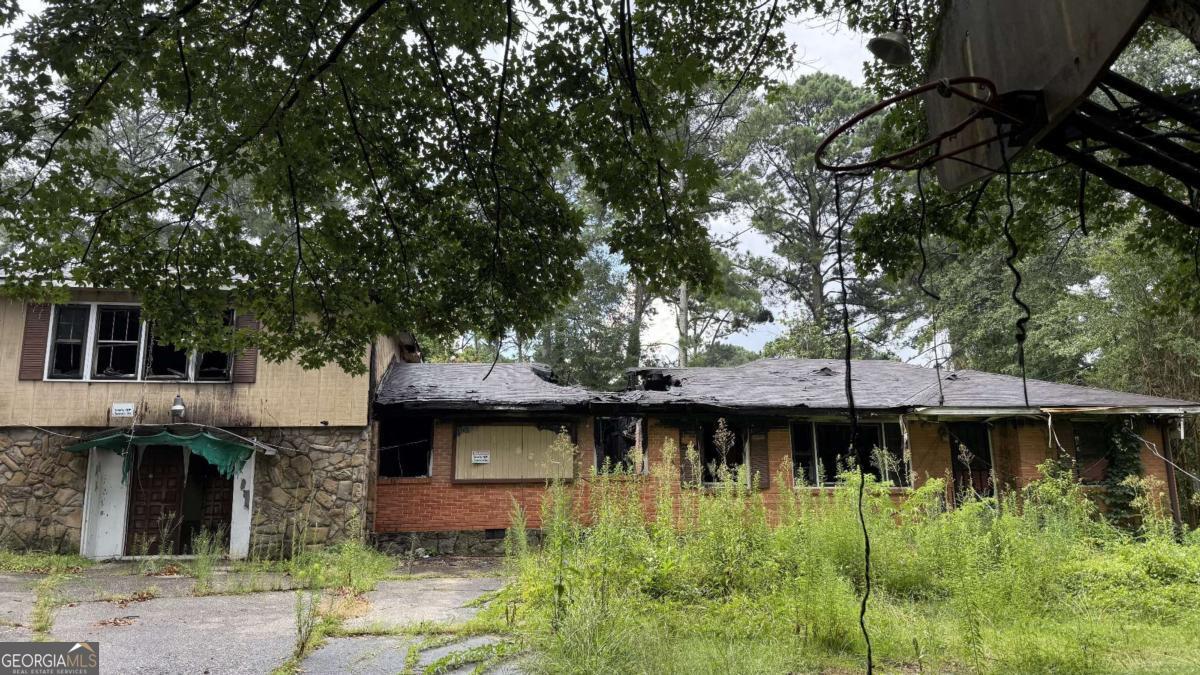 Investor Special! This fire-damaged property presents a prime opportunity for a complete rebuild. Ideal for investors or flippers-cash only. Previously configured as four separate rental units, the home offers strong income potential once restored. Situated on a large corner lot near the airport, with easy access to shopping, dining, and major highways. The spacious backyard provides ample room for future expansion or outdoor amenities.