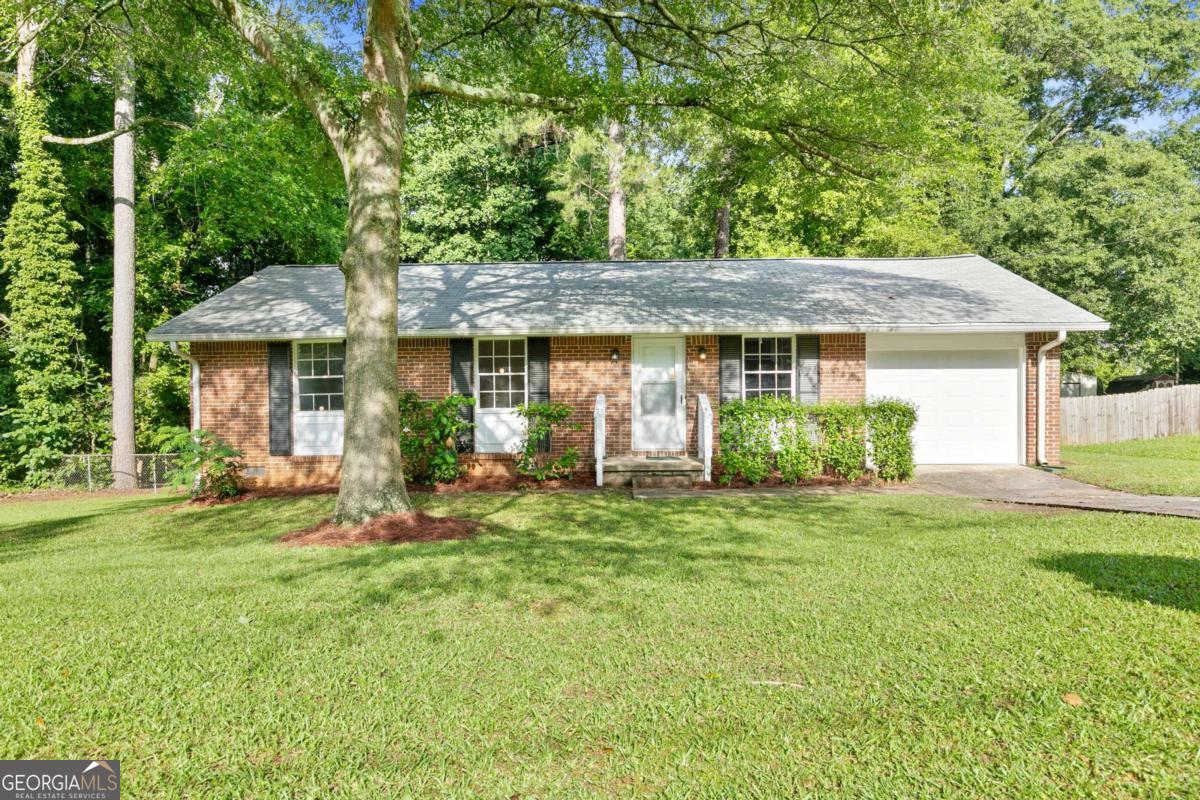 As we step into 6671 Gano Drive, let me show you why this one stands out. This 3-bedroom, 2-bathroom brick ranch has been meticulously maintained and thoughtfully updated, offering a blend of charm, comfort, and peace of mind that's hard to come by. Right away, you'll notice the curb appeal - that classic four-sided brick and the privacy of a tree-lined lot. Walk around back and you'll find a fully fenced yard and a quiet creek that runs along and behind the property - it's peaceful, calming, and gives the home a tucked-away feeling that's rare, especially with no HOA. Now step inside. One of the first things you'll see are the beautifully refinished hardwood floors, bringing warmth and character to every room. The natural light hits just right, especially with the fresh paint and updated lighting throughout. Every light fixture, every door handle, every detail has been chosen to create a clean, inviting space. The kitchen has been updated with gorgeous new granite countertops and is perfectly set up for both everyday living and hosting - whether you're prepping dinner or chatting with guests while you cook. Down the hall, there are two comfortable guest bedrooms, an updated guest bathroom, and the primary suite, which features its own private bath - both bathrooms have been updated with new tile work and modern finishes, along with durable vinyl flooring for a sleek, low-maintenance touch. The updates don't stop at what you can see. Behind the scenes, the home features a newly installed AC system, a newer roof, new garage door, added attic insulation, and a full moisture barrier in the crawlspace - all part of the effort to keep the home running efficiently and protected from top to bottom. A whole-home security system is already in place for added peace of mind. This home isn't just move-in ready - it's been loved and looked after, and it shows. And if you need to commute or travel, you're less than 20 minutes from both the Atlanta airport and downtown - so convenience is never a question. 6671 Gano Drive isn't just a house - it's the kind of place that feels like home from the moment you step inside. I'd love for you to experience it in person. Let's schedule your private tour and see if this is the one you've been waiting for.