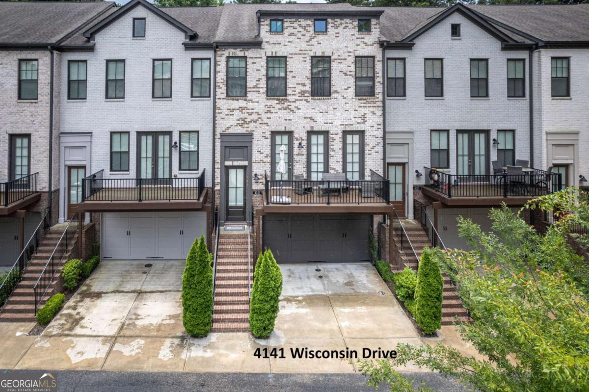 Welcome to 4141 Wisconsin Drive-an exceptional 3BR/3.5BA townhome in the gated Georgetown Square community. Built in 2018, this 2,471 heated sqft Cambridge plan spans three beautifully finished levels. The open-concept main level features engineered wood flooring, 10' ceilings, and a gourmet kitchen with Bosch stainless steel appliances, quartz counters, designer tile backsplash, white cabinetry, a spacious island, and pantry. Enjoy both a rear grilling deck and a front-facing balcony with tranquil courtyard views. The living area centers around a stacked-stone gas fireplace with custom wood mantel-ideal for entertaining or relaxing evenings. Upstairs, the luxurious primary suite offers a soaking tub, frameless glass shower, dual vanities, and large walk-in closet. A spacious secondary bedroom with its own full bath and walk-in closet completes the upper level. The terrace-level bedroom with full bath is perfect for guests or a home office. Includes a true two-car garage. The convenience of 4141 Wisconsin Drive is unmatched-walk to top-rated Dunwoody schools, scenic parks, and public transit. Minutes from Perimeter Mall, I-285, GA-400, and I-85, this prime location is the cherry on top of an already stunning home.