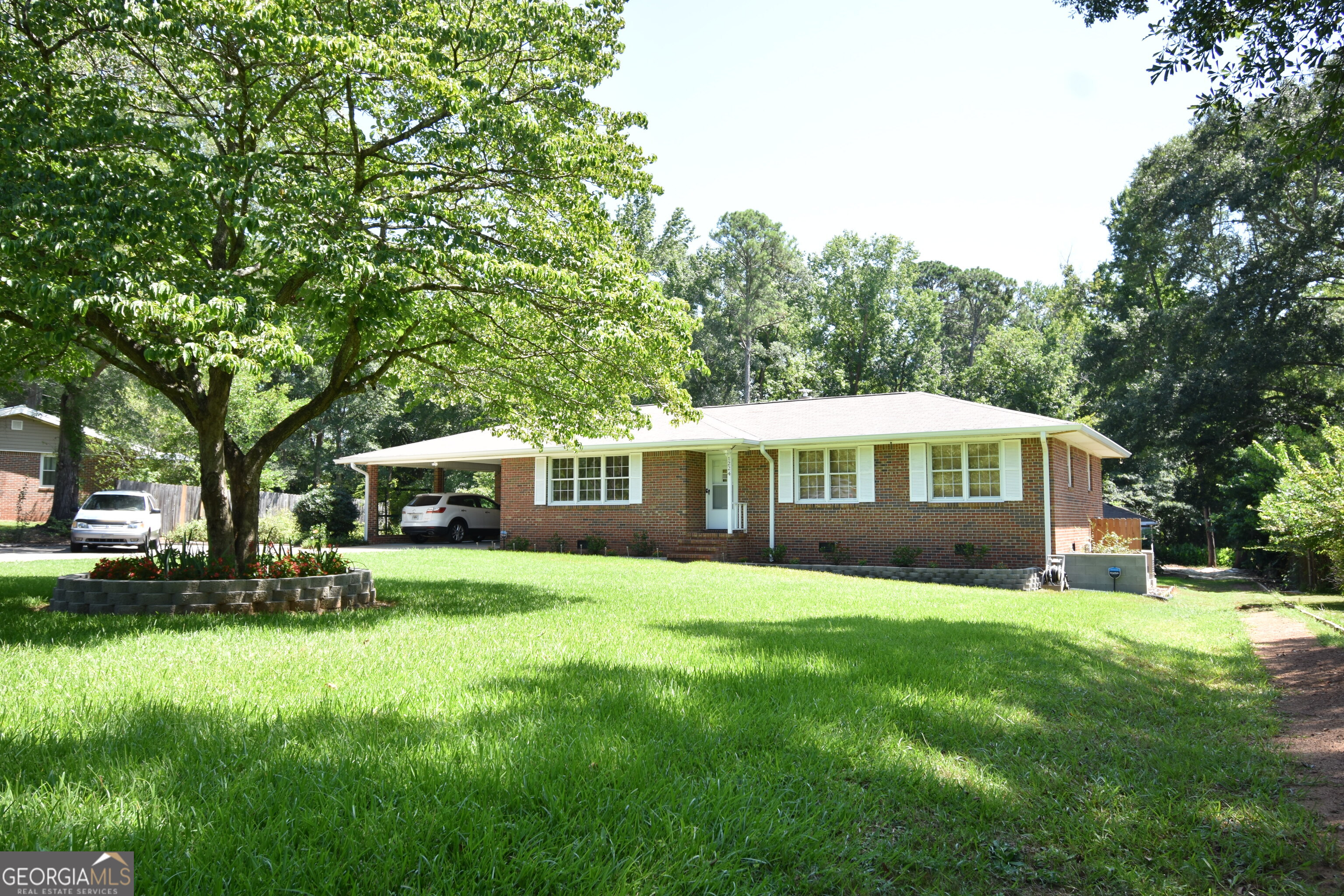 Well maintained Brick Ranch with Massive Workshop/Garage! Welcome to 1224 Ethridge Mill Rd -a cozy, clean 3-bedroom, 2-bath 4-sided brick ranch on a crawlspace nestled on .74 of an acre in the highly desirable Will Hill Newton neighborhood. This home has been refreshed, nicely landscaped and is move-in ready. Neutral paint accents the durable 12 mil laminate flooring throughout. The kitchen has new stainless steel appliances, white modern cabinets, and lovely windows overlooking the deck and back yard. The spacious living areas are enhanced by new ceiling fans and a NEW (2024) wood burning fireplace insert. There is a whole house fan, newer HVAC unit and even a FULL house Kohler generator installed in February 2025. The house boasts 200 amp service in the panel and the electrical lines outside were moved underground. Step outside and relax on the 12x12 wood deck overlooking the spacious, lush yard with view of the garden. There is a potting shed area adjacent to the shop - perfect for the garden enthusiast. There is a two car oversized carport and plenty of extra parking next to the driveway for guests or extra vehicles. Who doesn't love a massive 1,300+ sq ft workshop/garage outbuilding? This shop is complete with its own separate 200-amp electrical service feeding a 150-amp panel and is also stubbed for natural gas -ideal for hobbyists, car enthusiasts, or anyone needing extra space. This property offers the perfect blend of modern updates, functionality, storage and space. Don't miss your chance to own this one-of-a-kind gem. Schedule your showing today before it is gone!