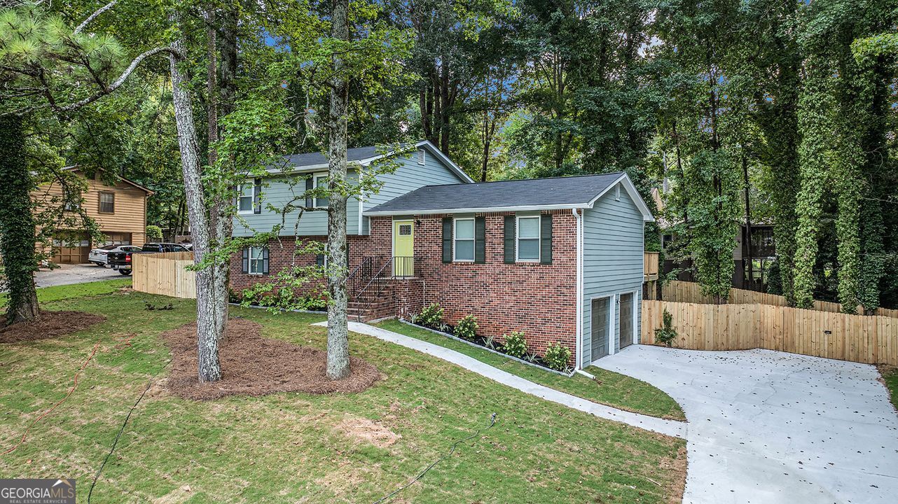 *Track record matters.* When the team behind your home's renovation has successfully transformed hundreds of properties across metro Atlanta, you know you're in good hands. Welcome to 1028 Martin Road, where decades of experience meet uncompromising excellence. Priced at $299,900 to bring immediate attention in today's market. Now, in a market flooded with cookie-cutter new builds and corner-cutting flips (where everything is apparently 'better than new!' and 'won't last long!'), this meticulously updated split-level offers something genuinely rare: real character enhanced by sophisticated modern upgrades done right. No lazy agent hyperbole here. No copy/paste descriptions drowning in desperate exclamation points. Just quality that speaks for itself. Start with what you'll notice from the curb-sturdy red brick foundation grounding sage green hardi-plank siding, crisp white trim harmonizing with rich olive shutters. And yes, a whimsical pop of chartreuse at the front door, hinting at thoughtful surprises inside. Those towering pines? They form a natural canopy that drops temperatures and fills your property with that peaceful whisper of pine needles. Let's step inside and feel the difference. Contemporary gray plank flooring flows seamlessly throughout, while the living room sets the tone with sophisticated palette and thoughtful lighting-perfect for intimate evenings or lively gatherings. The kitchen is where this home really shines. Slate-gray cabinetry reaches the ceiling, granite countertops stay cool to the touch, and professional stainless appliances make cooking a joy. No need for 'chef's dream!' exclamations when quality speaks for itself. The adjacent dining room handles everything from homework to holiday feasts with equal grace. Upstairs, three spacious bedrooms offer true private retreats. The primary suite feels genuinely peaceful as updated windows buffer outside noise while morning light filters in softly. There's a walk-in closet that actually fits your wardrobe, and a beautifully remodeled primary bath. Two additional bedrooms share a second full bathroom with spa-like finishes, one already showcasing home office potential. But here's the game-changer: a spectacular lower level. Nearly 600 square feet with cozy fireplace, currently the ultimate recreation room but ready to become whatever you need-theater, teen suite, creative studio. Light a fire on cool evenings and watch the space transform. And with third full bathroom, laundry, and direct garage access daily life flows seamlessly. Step outside to your private retreat beneath majestic pines. The elevated deck overlooks a landscaped yard where mature trees provide natural shade and fresh pine scent. Sure, we could type 'great for entertaining!' and move on. But when you've got natural architecture and a deck positioned for morning coffee and evening wine, why settle for shortcuts? This space deserves better. So do you. Location-wise, you couldn't ask for more. This established Stone Mountain neighborhood radiates pride, yet you're minutes from Highway 78 and I-285. Stone Mountain Park's 3,200 acres feel like your extended backyard. The Village provides eclectic shops and restaurants where neighbors know each other. Quality schools, Yellow River Trail, Mall at Stonecrest-everything's covered. This isn't some surface flip. We're talking comprehensive renovation-new roof, updated systems, designer finishes. Every detail reflects what happens when experience meets vision. Perfect whether you're first-timers skipping the starter phase, growing families needing space, or savvy investment minded buyers recognizing opportunity. Finding 2,036 square feet of thoughtfully updated space at this price point is increasingly difficult. We could hit you with urgency tactics, but let's be honest-you've read enough. Time to trust your own eyes over any agent's adjectives. When you're ready to see what quality looks like, 1028 Martin Road speaks for itself.