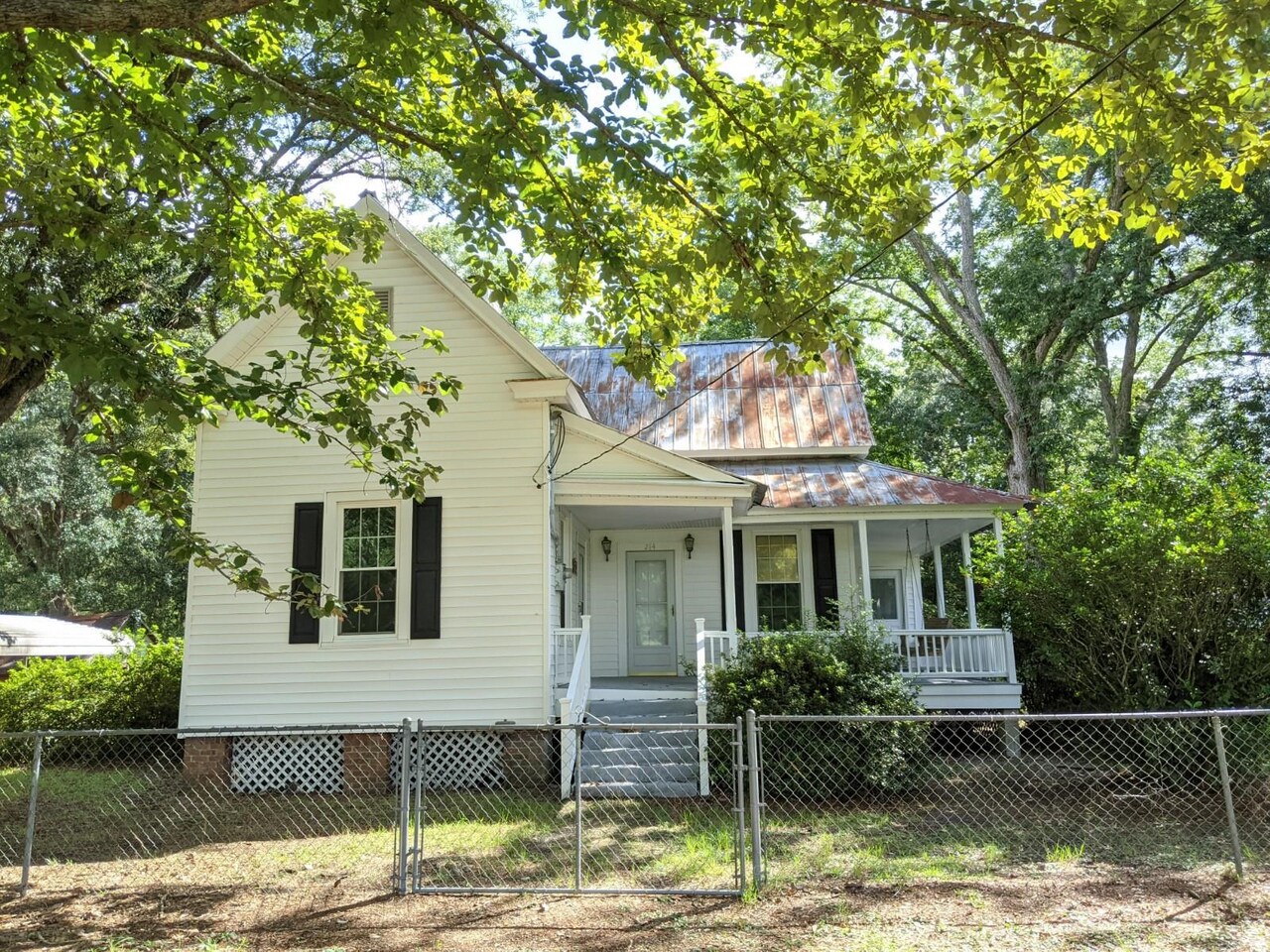 Country living at its best! Newly painted 3 bedrooms, 1 bath home with real wood flooring throughout and new carpet in the back bedroom. Wood stove fireplaces throughout for decorative purposes. Kitchen is equipped with refrigerator, stove and breakfast area for your table. Separate laundry room with W/D hookups. Wrap-around front porch and covered back porch with hanging swings. Completely fenced in yard with an electric gate for access into two car carport. No pets!