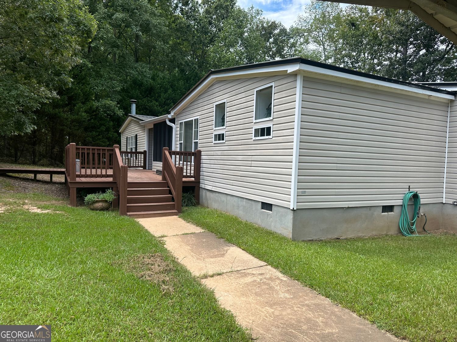 Backyard Fishing on 5 Acres - Escape to your own private retreat with this spacious 4-bedroom, 2-bath modular home offering over 3,000 sq. ft. of living space. The open floor plan features a large kitchen with a pantry and lots of counter space, separate dining room, great room, and additional living room-perfect for entertaining or everyday comfort. Step outside to the covered deck and take in the peaceful views of your very own private pond, ideal for relaxing evenings or a little backyard fishing. All set in a quiet, 5-acre country setting just minutes from town.