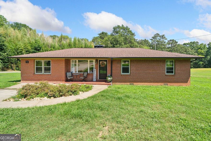 Live, work, and play in the perfect blend of privacy and convenience. This comfortable four-bedroom home sits in a peaceful rural setting with quick access to Highway 20, Vickery Village, and GA 400. Whether you're looking for a personal retreat or a place to launch your next venture, this property delivers flexibility and charm.  Step inside to find a warm family room. It has a cozy masonry fireplace, perfect for relaxing evenings or hanging out with friends. The large eat-in kitchen offers plenty of room for cooking and conversation, with a layout that encourages connection. Need extra space for an active lifestyle? The bonus room can serve as a home gym, playroom, or studio, complete with direct access to the outdoor deck.  Just steps from the main home is a spacious workshop featuring a barn-style garage door and a concrete drive that extends all the way to the street. This workshop is perfect for you. Whether you run a small business, restore classic cars, or just need a space to create and relax, it offers endless possibilities.  The half-acre lot offers plenty of room to spread out and enjoy the outdoors. Bring your toys, plant a garden, enjoy the fruit trees, or gather fresh eggs from your own chicken coop. This property gives you the breathing room you crave while still keeping you close to schools, shops, and commuter routes. Located in the highly rated Freehome Elementary and Creekview High School district, it offers both peace of mind and convenience.  Welcome home to a lifestyle that works for you.