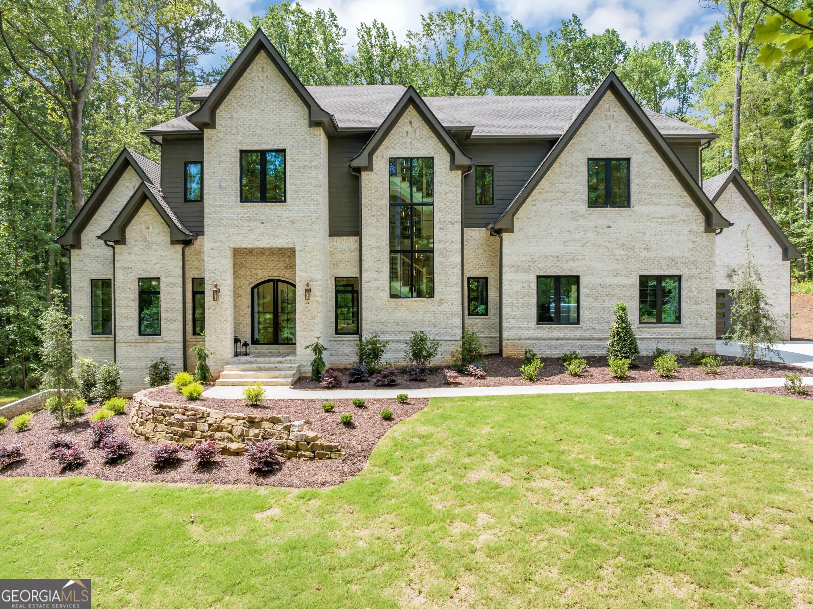 Welcome to an extraordinary new construction custom estate nestled on 3 private, level acres in one of Alpharetta's most desirable locations. Boasting approximately 8,500 square feet, this 4-side brick home features 7 spacious bedrooms, 7 full baths, 2 half baths, and 4 luxurious levels of living space, including a finished terrace level with a private in-law suite and kitchen. From the moment you enter, you're greeted by soaring 12-foot ceilings on the main, 10-foot ceilings upstairs and in the basement, and custom architectural details that exude sophistication and grandeur. The open-concept layout is designed for both elegant entertaining and comfortable everyday living. The chef's kitchen is a dream, featuring high-end Sub-Zero/Wolf appliances, a massive quartz island, expansive walk-in pantry, and a secondary full-service kitchen, ideal for multi-generational living or large gatherings. Flowing seamlessly into the fireside family room and dining area, this space opens to a covered outdoor patio with fireplace, offering serene views of the private backyard perfectly suited for a future pool or outdoor oasis. Enjoy your morning coffee with peaceful private views from your master bathroom balcony, a rare luxury and the perfect retreat to start your day. Main-level highlights include dual guest suites with private baths, a mudroom/drop zone, and epoxy-finished 3-car garage. The owner's suite upstairs is a true retreat with dual oversized walk-in California closets, and a spa-style bathroom. Each secondary bedroom in the home offers its own en-suite bath for ultimate privacy and comfort. The terrace level adds unmatched flexibility with a full second kitchen/bar, media room, gym, golf simulator or theater space, and walk-out access making it perfect for in-laws or guests. Notable upgrades include: Spray foam insulation throughout (including between floors for soundproofing), 5-inch hardwoods on all 3 levels + luxury LVP in the basement, 2 laundry rooms (main & upper), Premium European aluminum windows & doors, Pre-wired for 24 speakers, smart light switches ready to be paired, Long private driveway with ample parking. Located in Alpharetta with low Forsyth County taxes and top-rated schools, this home offers an unparalleled blend of elegance, function, and convenience. No HOA. Close to downtown Alpharetta, The Avalon and Halcyon plazas, Lake Lanier, HWY Ga-400 and etc. There is truly nothing else like it on the market. Schedule your private tour today and experience luxury redefined! ***OpenHouse on Sunday, September 7th from 2 to 4 pm***