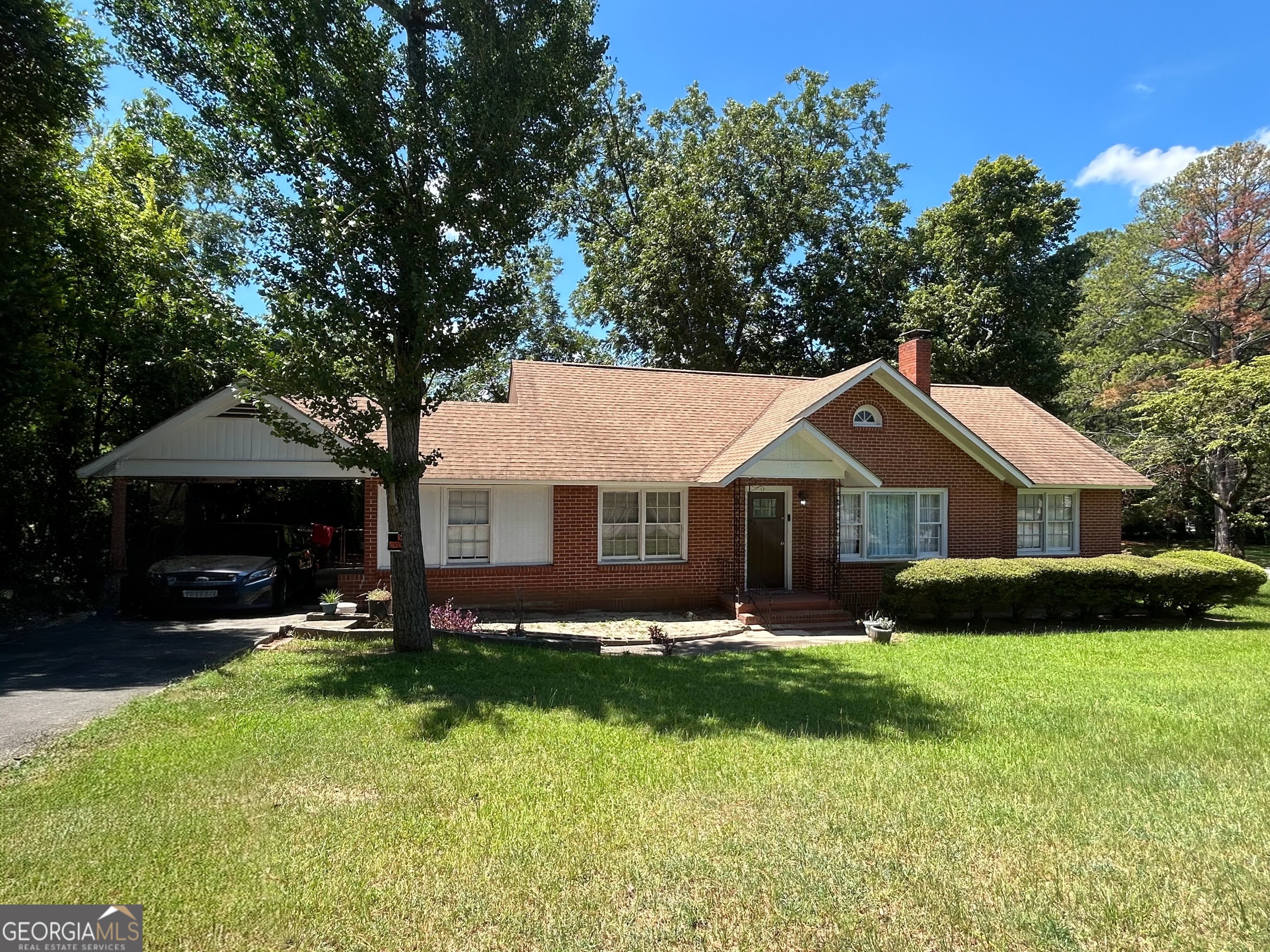 Solid and spacious, this four-sided brick home sits proudly on a large fenced corner lot with mature landscaping and a producing pecan tree in the backyard. Enjoy outdoor living on the rear patio, with plenty of room to relax or entertain. Inside, you'll find generously sized bedrooms, original hardwood floors full of character, and a cozy wood-burning fireplace in the main living area. The bonus room adds flexibility-perfect for a home office, den, or playroom. Additional highlights include a covered carport, dedicated laundry room, and two backyard storage buildings. Major systems have been updated with a roof and HVAC system both just 4 years old. Whether you're adding to your portfolio or looking for a primary residence, this well-maintained home offers timeless appeal and room to grow. Being sold in As-Is condition.