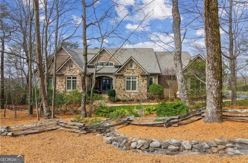 ABSOLUTELY STUNNING VIEWS OF LAKE PETIT AND MOUNTAINS!!! This is a rare opportunity to own one of the BEST views in all of Big Canoe and yet only 5 minutes travel time to the North Gate. This fabulous like new home was featured on the 2014 Big Canoe Tour of Homes and just recently was remodeled to include white shiplap siding throughout the entire home, giving this already gorgeous home a light and bright look with a contemporary feel, highlighted by tasteful designer furnishings at every turn. The large Master BR Suite with renovated bathroom has his and her closets, and one of the closets has been modified to house a new Clearlight Infrared Sauna unit which can be removed if so desired. Main level also offers a 2nd BR with direct access to a separate full bath and can also be used as an office/study. Main level living areas include a spacious great room with cathedral wood ceilings, stacked stone fireplace, a cozy family/keeping room with its own stone fireplace, a formal dining room ideally suited to accommodate large family gatherings. The terrace level with a mini kitchen and wine cooler, wine storage room, fireplace, two bedrooms plus an oversize bonus space currently being utilized as a bunk room, can also be utilized for exercise/hobby room or even a private in-law suite for family and overnight guests. The billiard room is a wonderful gathering place for family fun and entertainment, plus enjoys its own private outdoor access to the backyard. Enjoy the majestic mountain views and serenity of Lake Petit any time of year from an expansive covered deck area on the main level equipped with a new Infratech heater and Trex decking, or large screen porch on the lower level. Gentle driveway with stacked stone retaining wall, stacked stone accent walls, flat flagstone walkway and a lovely water fountain feature sits just off your front entry porch to beautifully compliment this very special home. This exquisite property can be sold turn-key with designer furnishings included. Truly a home you need to come see for yourself!