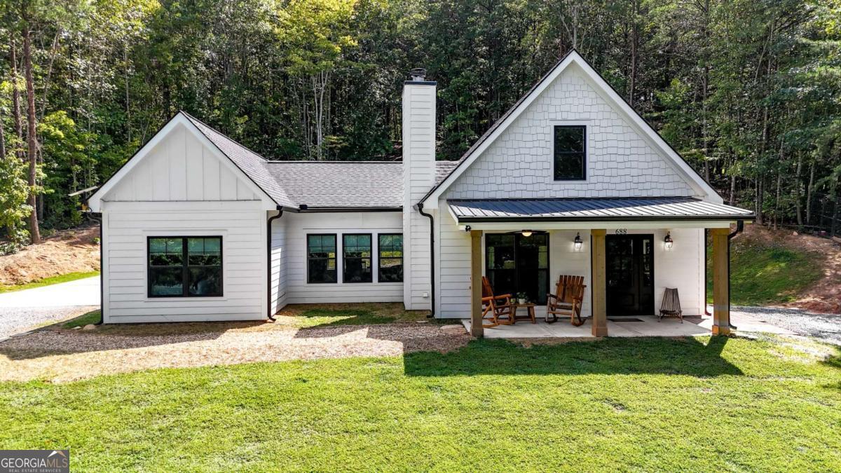Welcome home to this beautifully maintained 2-bedroom, 2-bath ranch nestled on a serene 5-acre lot-offering the perfect blend of peace, privacy, and modern comfort. Thoughtfully designed with open-concept living, this home features soaring ceilings and a charming loft that overlooks the spacious main living area, adding warmth and character. The flexible floor plan easily allows for the transformation to a third bedroom, making it ideal for growing families or guests. Enjoy your mornings on the inviting front porch and unwind in the evenings on the expansive back porch, both perfect for relaxing and rocking the day away while taking in tranquil views of your private acreage. Whether you're dreaming of homesteading, gardening, or simply enjoying wide-open space, this better-than-new gem offers endless possibilities.