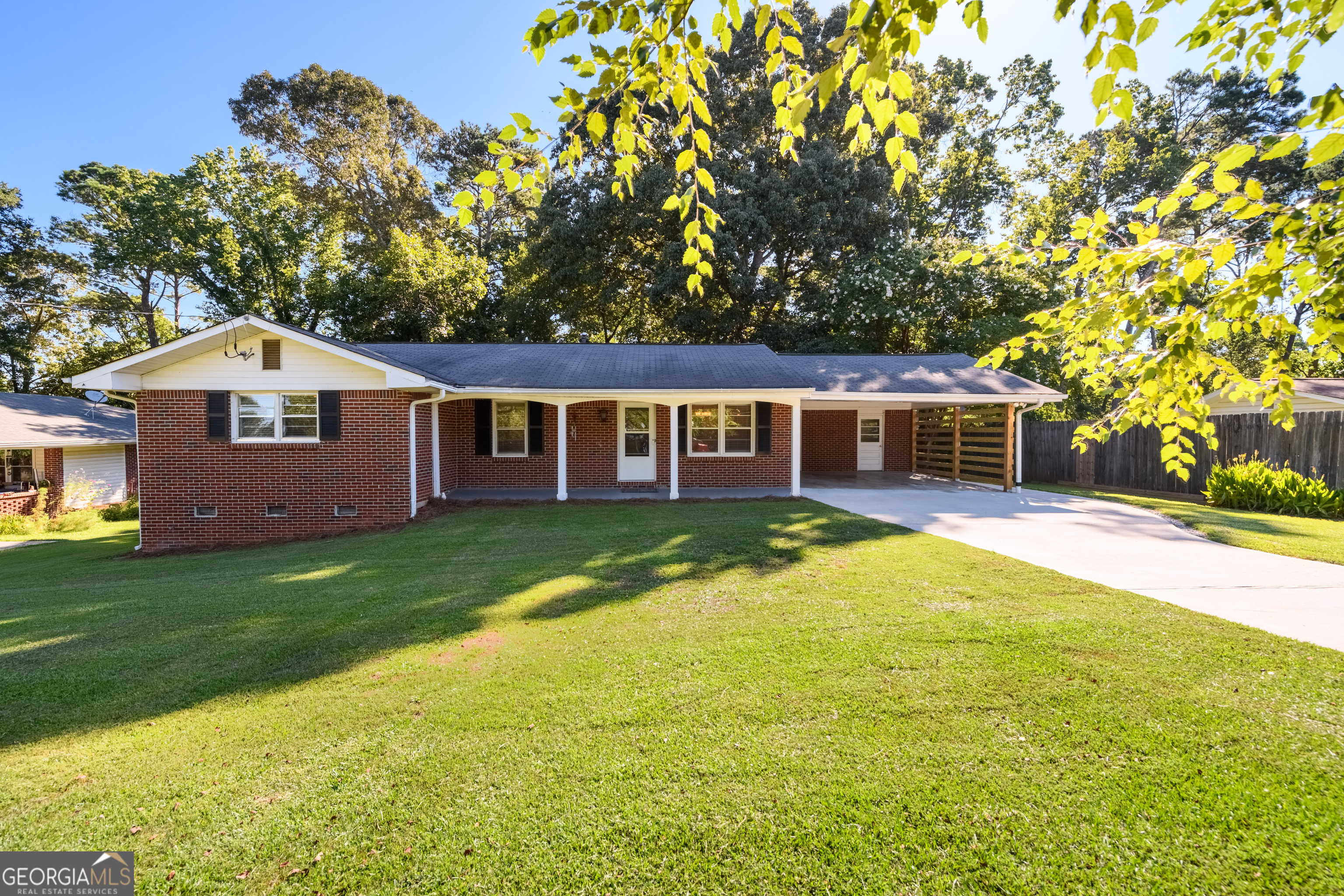 Welcome home to this beautifully updated brick ranch on a large, level lot with partially fenced, private backyard and inviting rocking chair front porch. Inside, enjoy an open layout perfect for everyday living and entertaining. The updated kitchen features white cabinets, granite counters, beadboard backsplash, gas cooktop, stainless-steel dishwasher, and a pantry with pull-out drawers for easy access. Dining area with modern chandelier flows into the spacious living room and out to a large deck overlooking the wooded backyard-ideal for relaxing, grilling & hosting guests. The primary suite offers a renovated bath with a tile shower, updated vanity, and fresh finishes. Secondary bedrooms share an updated hall bath with tile floors and tub/shower. Gleaming hardwood floors and 2" blinds throughout. Includes an outbuilding for extra storage and a brand new septic system-huge savings and peace of mind! Tucked away on a quiet cul-de-sac, yet convenient to everything. A true gem!