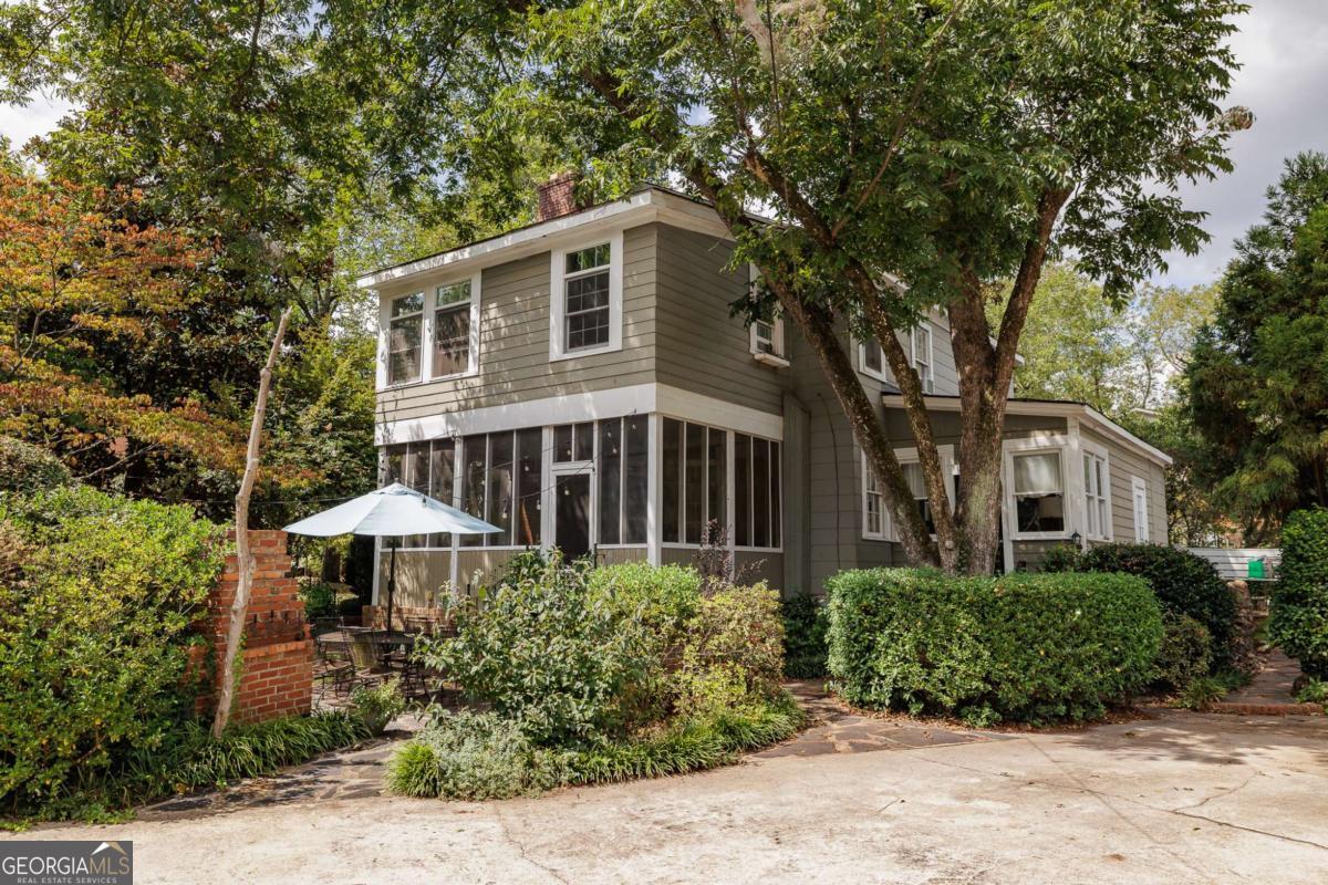 Welcome to 1697 South Milledge Avenue, a hidden gem located in Athens favorite neighborhood and on one of its most storied streets! This home is replete with character and charm and is surrounded by mature landscaping with an extraordinary level of privacy, yet is an easy walk from all that historic Five Points has to offer. This 3 bedroom, 3.5 bath home offers an additional flex room that can be used as a guest bedroom, office, or home gym. The detached two car garage features a 1 bedroom, 1 bath apartment upstairs with strong short and long term rental history. This is a ready-made ADU! Inside the main home, features such as heart of pine flooring, exposed wood beams and brick masonry make this property an unbelievably unique find. Between the kitchens adjoining bright and cozy sunroom, the southward facing screened-in porch and the outdoor patio and fireplace, there are plently of options to enjoy a morning coffee, afternoon book, or just relax with friends and family while taking in views of the beautiful surroundings. The owners suite, with an en-suite bath and walk-in closet, provides even more outdoor living space, offering a private balcony overlooking Milledge Avenue. Walk to Sanford Stadium for a perfect Fall Saturday in Athens, enjoy a leisurely stroll to Five Points proper for lunch, or dine al fresco at 1697 South Milledge. Dont miss your opportunity to experience Southern living in this one-of-a-kind home!