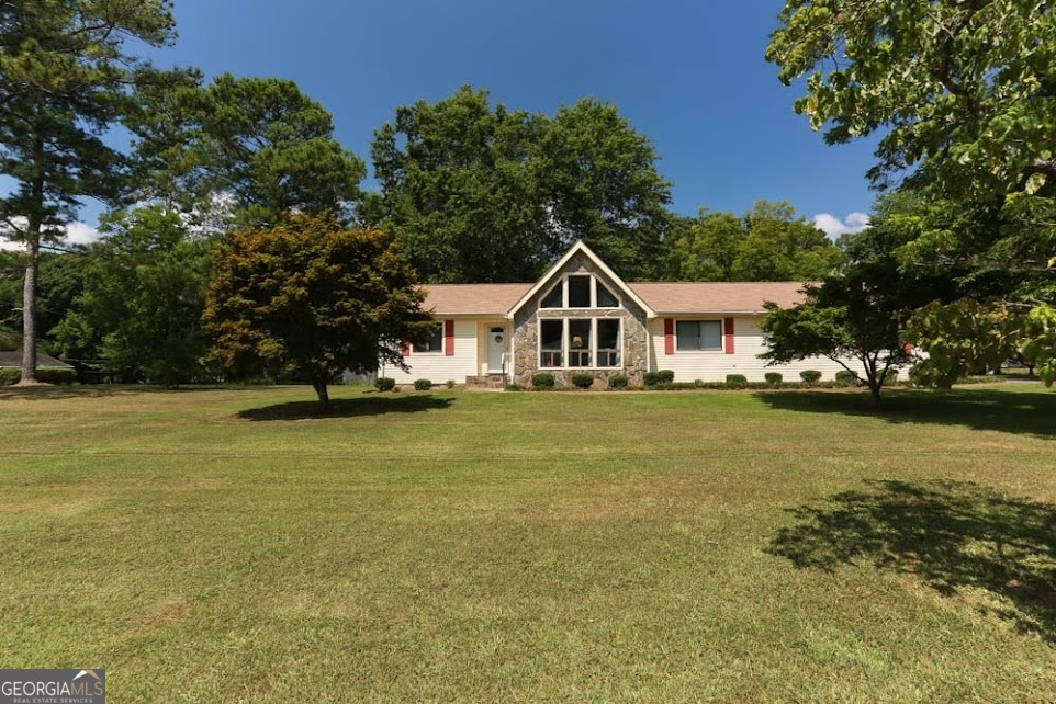 Perfect OPPORTUNITY is knocking! NO STEPS ranch home sitting on a HUGE LEVEL corner lot conveniently located in a quiet, established neighborhood in west GA with NO HOA! The high ceilings with WOODEN BEAMS, with a FIREPLACE that is sure to grab your attention in this open space! NEW flooring in foyer and kitchen, with carpet in spectacular condition! All this home needs is a little paint and imagination to make this lovely 3-bed, 2-bath home your own! Plenty of storage throughout this home with a large walk-in closet in the owner's suite. A back deck with a gas grill expands the backside of the home for all your entertaining desires or simply enjoying nature. Don't forget the OPTIONAL pool association! This is the only neighborhood in West GA with an optional pool and green space for you and your guests during the summer months! Schedule your showing today! **Some photos have been virtually staged**