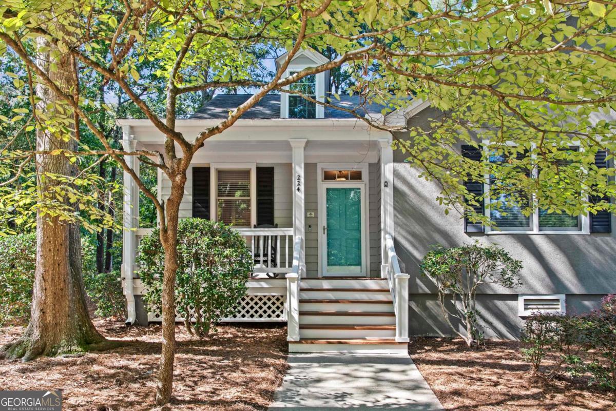 EFFORTLESS RETREAT WITH GOLF COURSE VIEWS AND INCOME POTENTIAL IN GREAT WATERS AT REYNOLDS LAKE OCONEE. Turnkey and tucked inside the prestigious Great Waters community, this inviting cottage blends timeless charm with the ease of refined golf course living. Overlooking the award-winning Jack Nicklaus Signature Course, the home offers both serene views and the opportunity for inclusion in the Reynolds rental program, making it as smart an investment as it is a retreat. A welcoming front porch leads you inside to a thoughtfully designed kitchen with stainless steel appliances, granite countertops, and bar-height counter seating that opens to the dining area, ideal as a breakfast or serving counter for entertaining. The dining room flows into the living space, where sliding glass doors invite effortless indoor-outdoor living. Just off the living area, the primary suite features a spa-like bath with a soaking tub and private deck access, while a comfortable guest bedroom with full bath completes the main level. A spacious private deck extends the living footprint, perfect for morning coffee or entertaining guests. Additional conveniences include a large pantry with plenty of storage and a dedicated laundry closet. This property truly captures the best of golf course living in one of Lake Oconee's most desirable communities!