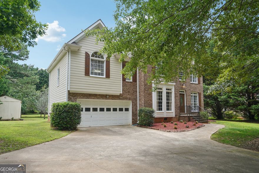 Discover the freedom of no HOA and the tranquility of a large, private backyard in this beautifully maintained home, just minutes from Lake Lanier!      The heart of the home is the fireside living room where soaring vaulted ceilings and expansive windows fill the space with natural light, creating a warm and inviting atmosphere. The stunning white kitchen, complete with an island breakfast bar and updated appliances-perfect for casual dining or entertaining guests. The spacious primary suite features a trey ceiling and a spa-like ensuite bathroom with dual vanities, a walk-in shower, and a separate soaking tub for ultimate relaxation.    Upstairs, you'll find three additional well-appointed bedrooms and a convenient laundry room. Step outside to enjoy the back deck overlooking the expansive yard-ideal for gatherings, gardening, or simply soaking in the peaceful surroundings. A shed provides extra storage for tools, hobbies, or outdoor gear. Refrigerator, Washer and Dryer all convey with the sale!     Don't miss this rare opportunity to own a serene, move-in-ready home with no HOA and close proximity to the lake, shopping, dining, and top-rated schools. Schedule your showing today!