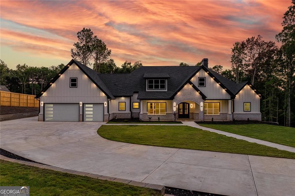A Rare Find in Monroe: Gated Ranch Estate with Pool, Privacy & Unmatched Charm on Over 2 Acres Welcome to a one-of-a-kind gated ranch estate where modern luxury meets relaxed, single-level living on 2.5 meticulously fenced acres. Thoughtfully designed for those who value space, privacy, and seamless indoor-outdoor flow, this home blends timeless design with everyday comfort in one of Monroe's most sought-after settings. A beautiful front porch with vaulted ceilings, oversized tile flooring, and a modern brick archway sets a grand first impression-balancing architectural charm with warm Southern hospitality. Inside, a solid wood front door opens into a dramatic great room with soaring vaulted ceilings, exposed stained beams, and a custom stone fireplace that anchors the space. Flanking the room are designer oak-lit built-ins and oversized iron and glass doors that lead directly to the private backyard retreat-bringing natural light and openness into the heart of the home. Step outside to enjoy your own resort-style sanctuary. A saltwater pool and spa, fireside covered porch, and fully equipped outdoor kitchen make this home an entertainer's dream-all set against a backdrop of wooded privacy and wide-open skies. The chef's kitchen is smartly designed with a custom wood hood, ceiling-height tile backsplash, walk-in pantry, and oak-accented built-in dining cabinetry-offering clean lines, quality finishes, and a layout that functions beautifully for both everyday living and entertaining. The primary suite is a true retreat, with direct pool access and a spa-inspired bath featuring a deep soaking tub, dual vanities, a rainfall + body-spray shower with floor-to-ceiling tile and built-in bench, and a custom walk-in closet built for simplicity, space, and organization. Each secondary bedroom is en-suite, with oversized, ceiling-tiled showers and custom closets-perfect for family or guests. A flexible bonus room adds even more functionality, complete with a wet bar (quartz counters, wood cabinetry, beverage cooler) and private half bath-ideal as a guest suite, game room, or media lounge. An iron door leads to a dedicated home office, offering privacy and focus without sacrificing style. The garage offers extended depth and a five-car capacity, complete with sleek showcase lighting-perfect for collectors, recreational vehicles, or simply elevated everyday convenience. Whether you're looking for the ease of single-level living, space to entertain, or room to spread out in style, this property delivers it all-just minutes from Downtown Monroe, George Walton Academy, the new YMCA, premier golf courses, and scenic parks. Homes of this caliber, location, and lifestyle rarely hit the market. Schedule your private tour today and experience Monroe's most exceptional ranch estate.