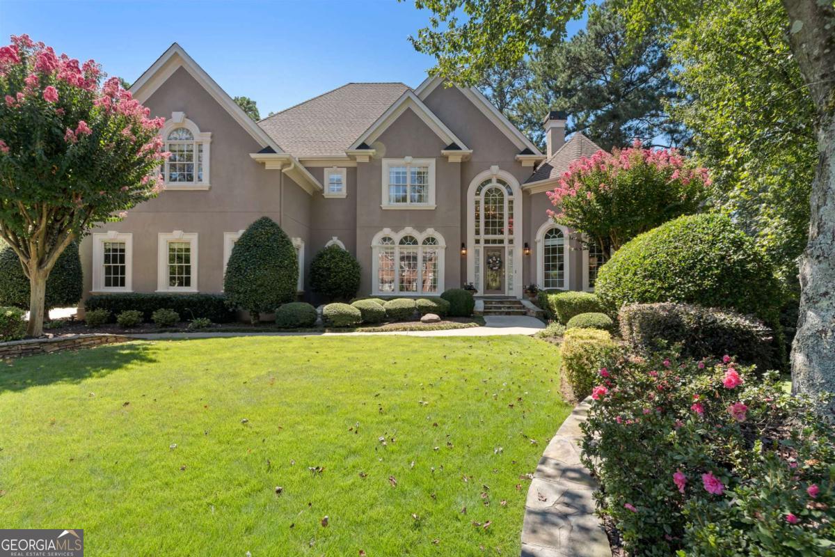 Step into timeless elegance with this meticulously maintained luxury home in the highly sought-after Falls of Autry Mill community. This residence is truly move-in ready, offering an open and inviting floor plan designed for both everyday living and unforgettable entertaining. A dramatic two-story foyer welcomes you, flanked by a formal dining room and a versatile living room/office. The heart of the home features a chef's kitchen with a butler's pantry, abundant counter space, and a bright breakfast room overlooking the stunning backyard oasis. Perfectly landscaped with lush greenery and a serene waterfall, the level backyard is ideal for children at play and outdoor gatherings. The main level also includes an oversized laundry room that makes chores a pleasure, plus a private guest suite with a full bath. Upstairs, the expansive primary suite offers a cozy fireplace, spa-inspired bath, and an oversized closet. The upper level also features two additional ensuite bedrooms, one of which includes a bonus room perfect for a play area or study space-this bonus room could easily be converted into a fourth bedroom upstairs to suit your needs. The terrace level is designed for entertainment, boasting a spacious recreation area, an additional bedroom, and a full bathroom. Living in The Falls of Autry Mill means access to world-class amenities including a state-of-the-art fitness center, 11 tennis courts, 2 pickleball courts, an Olympic-size pool, a tranquil zen pool, and a vibrant calendar of community events. All of this in Johns Creek-named the Best City to Live in 2025 by U.S. News & World Report. This home is more than a residence; it's a lifestyle.