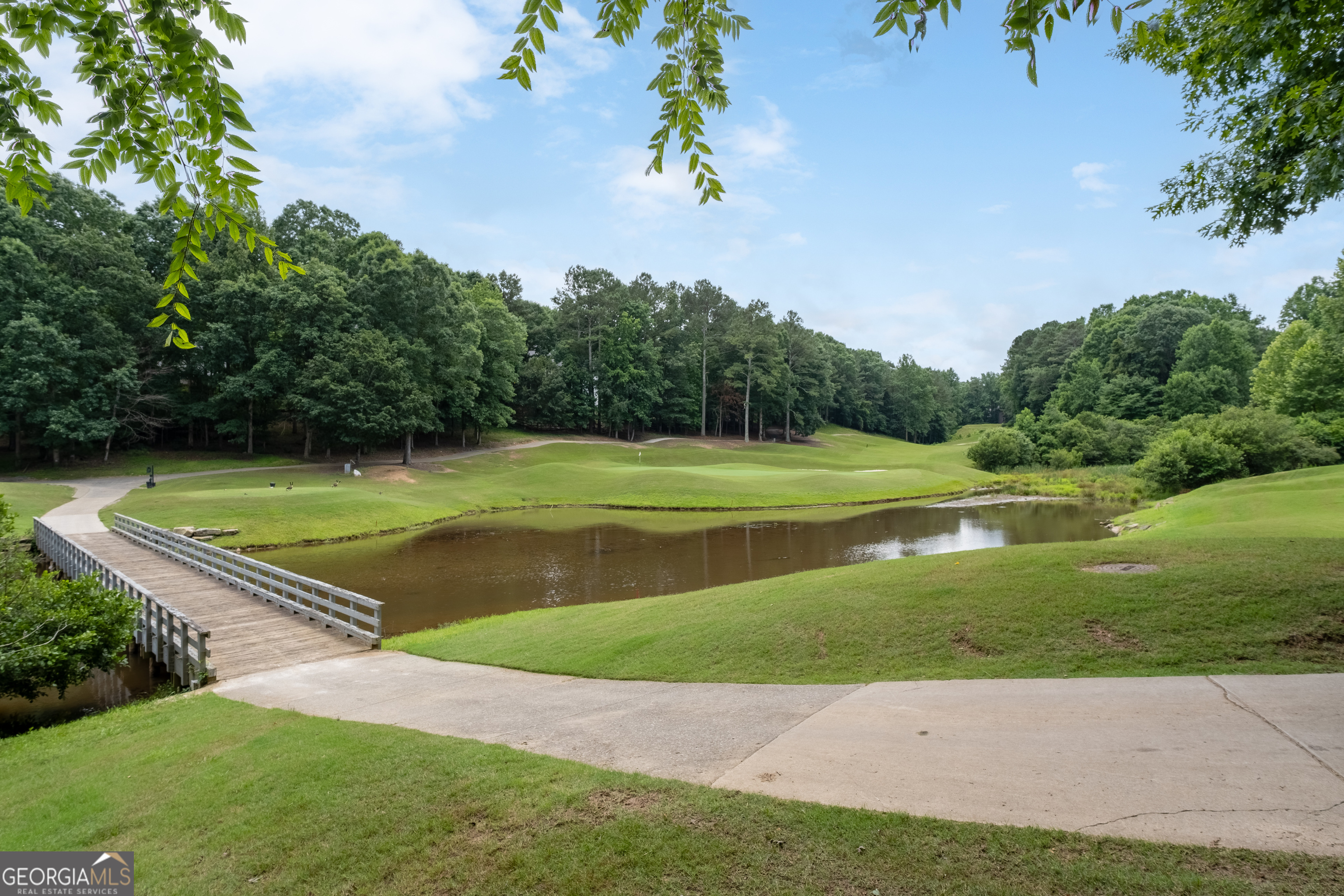 Amazing views of the Eagle Watch GOLF COURSE, tranquil POND, charming cart bridge, plus CORPS of Engineer property beyond!* Just under ONE ACRE!* Original owners have taken meticulous care of this beautiful home!* High quality/low-maintenance features!* Three lovely levels* Spacious primary bedroom with sitting room features bay windows to the front and the rear! Updated primary bath with double vanity, tiled shower, whirlpool tub, frameless glass shower, separate water closet, and roomy walk-in closet!* Two more large bedrooms up share divided bath!* HUGE laundry room with utility sink!* Ample closet space!* Main level includes a private bedroom and bath in addition to a half bath for guests!* Vaulted great room with gas log fireplace, built-in bookcases, and finished sunroom!* Hardwood floors in living and dining rooms!* Updated kitchen with warm stained cabinets, granite counters, stainless appliances, pantry, breakfast bar and island!* Energy efficient/low maintenance windows and doors throughout!* Front and rear stairs!* Central vacuum!* Sprinkler system!* Easy care Trex-like decking!* Terrace level includes a spacious and bright family room with fireplace, ample storage, bedroom and full bath, a massive workshop/flex zone plus a private covered deck!* Additional storage in sub-basement room!* Thirty blueberry bushes in the fenced rear yard!* Walking distance to the desirable Eagle Watch amenities - golf course, pools, tennis and pickleball courts, playground, clubhouse!* Just minutes to Downtown Woodstock!* Walk to shopping, restaurants, ballpark, library, and the Greenprints Trails!* All the best schools - Bascomb Elem, Booth Middle and Etowah High!*
