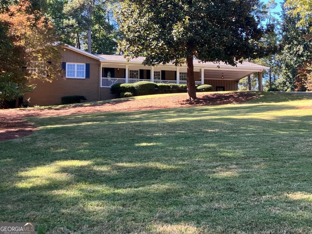 Welcome to this stunning fully updated brick ranch nestled in prestigious Whitlock Heights. Located minutes from the charming Marietta Square, this home seamlessly blends traditional charm with modern updates. Formal Living Room and separate Dining Room; bright and airy Kitchen with designer finishes including quartz counter tops, island, striking tile back splash and sleek stainless steel appliances. 3 Bedrooms and 2 Full bathrooms. Hardwood floors throughout. Fireplace in Den. New laundry area off the Den. All new interior and exterior paint and stylish new light fixtures throughout. Partial unfinished basement stubbed for bath. Situated on spacious 1.1 acre lot, the backyard is perfect for outdoor fun and relaxation. Large deck for entertaining. The Storage Room in the carport has a built in work bench and electricity. Close to shopping, dining, parks, schools and more. This home truly has it all! This lot also has access to Chestnut Hill Road. Perfect if purchaser want's to build garage or storage building.