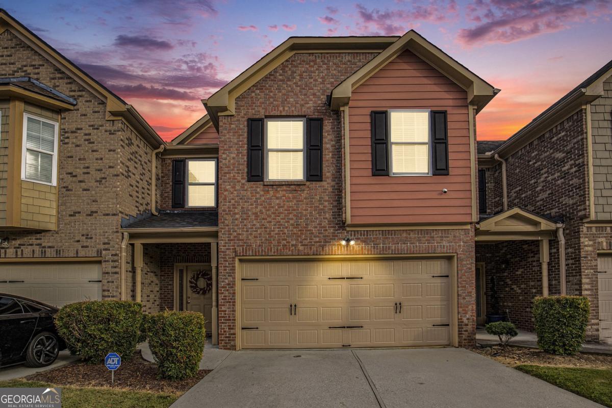This beautifully maintained brick townhome is tucked away in a quiet, charming community in the heart of Snellville. Step inside through a covered front porch into a welcoming foyer and hallway that leads to a spacious eat-in kitchen featuring a breakfast bar, stainless steel appliances, 42-inch wood cabinets with crown molding, a pantry, and new LVP flooring throughout the lower level. The open-concept layout flows into a large family room with a cozy fireplace-perfect for relaxing or entertaining. The roof was newly replaced in 2023, adding peace of mind for years to come. Upstairs, you'll find three generously sized bedrooms and two full bathrooms. The oversized primary suite boasts a sitting area, two walk-in closets, and a luxurious en-suite bath complete with dual vanities, a soaking tub, and a separate shower. The secondary bedrooms share a hallway with a small loft/common area and a convenient laundry room. A guest powder room is located on the main level for added convenience. Additional highlights include a two-car garage and a fenced-in backyard with a private patio-ideal for outdoor dining or quiet evenings. Enjoy easy access to local shops, restaurants, hospitals, top-rated schools, and major highways including I-285, I-20, and I-85.